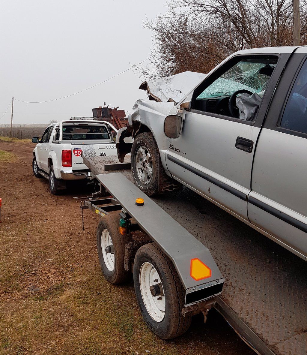 Un camión está remolcando un automóvil en un remolque.