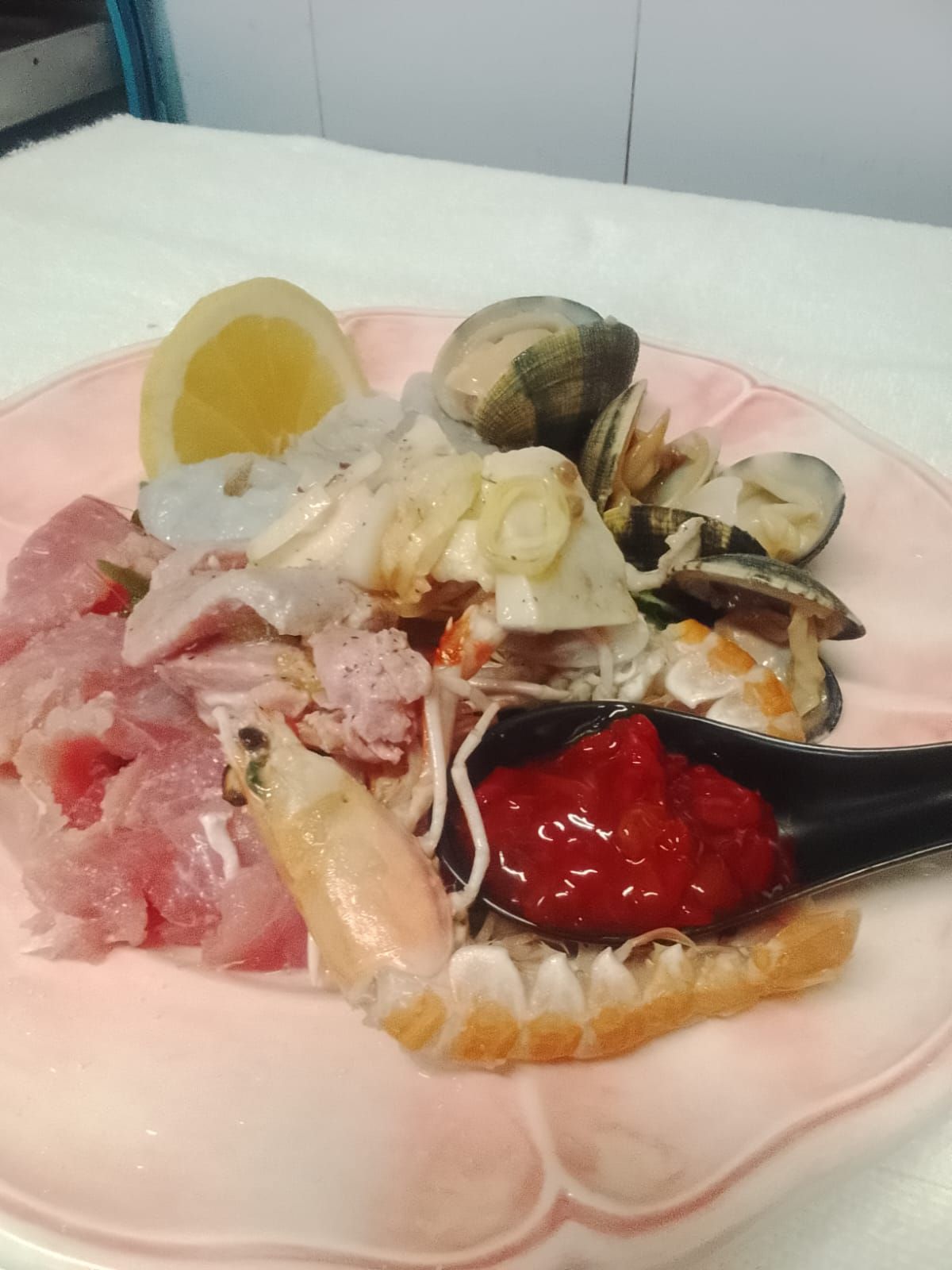 Un piatto di frutti di mare con un cucchiaio dentro