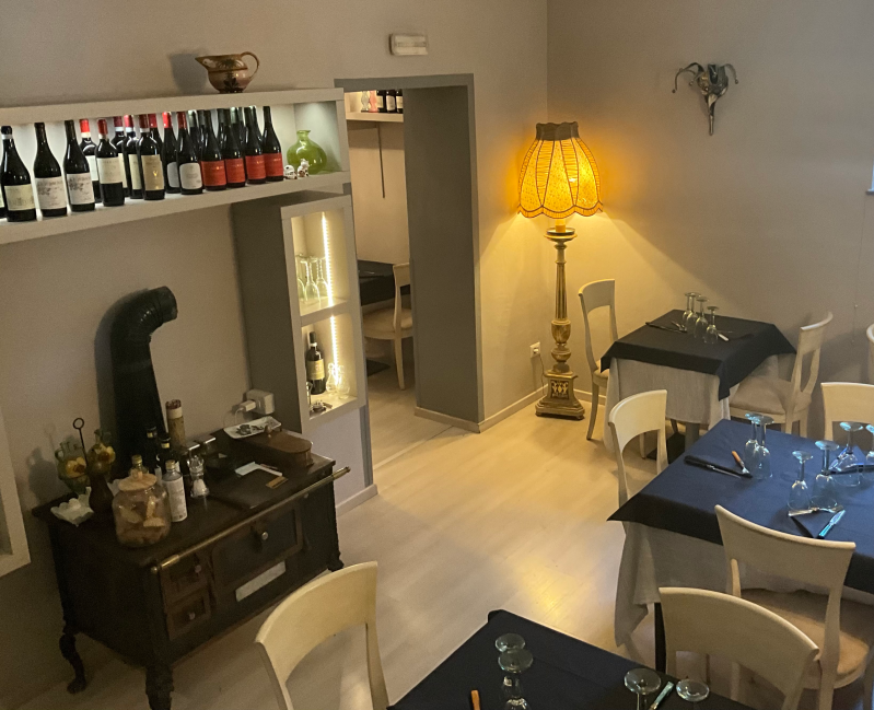 Una sala da pranzo con tavoli, sedie e una lampada