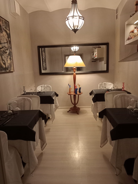 Una sala da pranzo con tavoli, sedie e una lampada