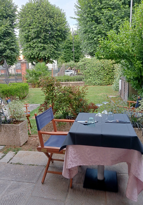 Un tavolo e delle sedie su un patio con alberi sullo sfondo.