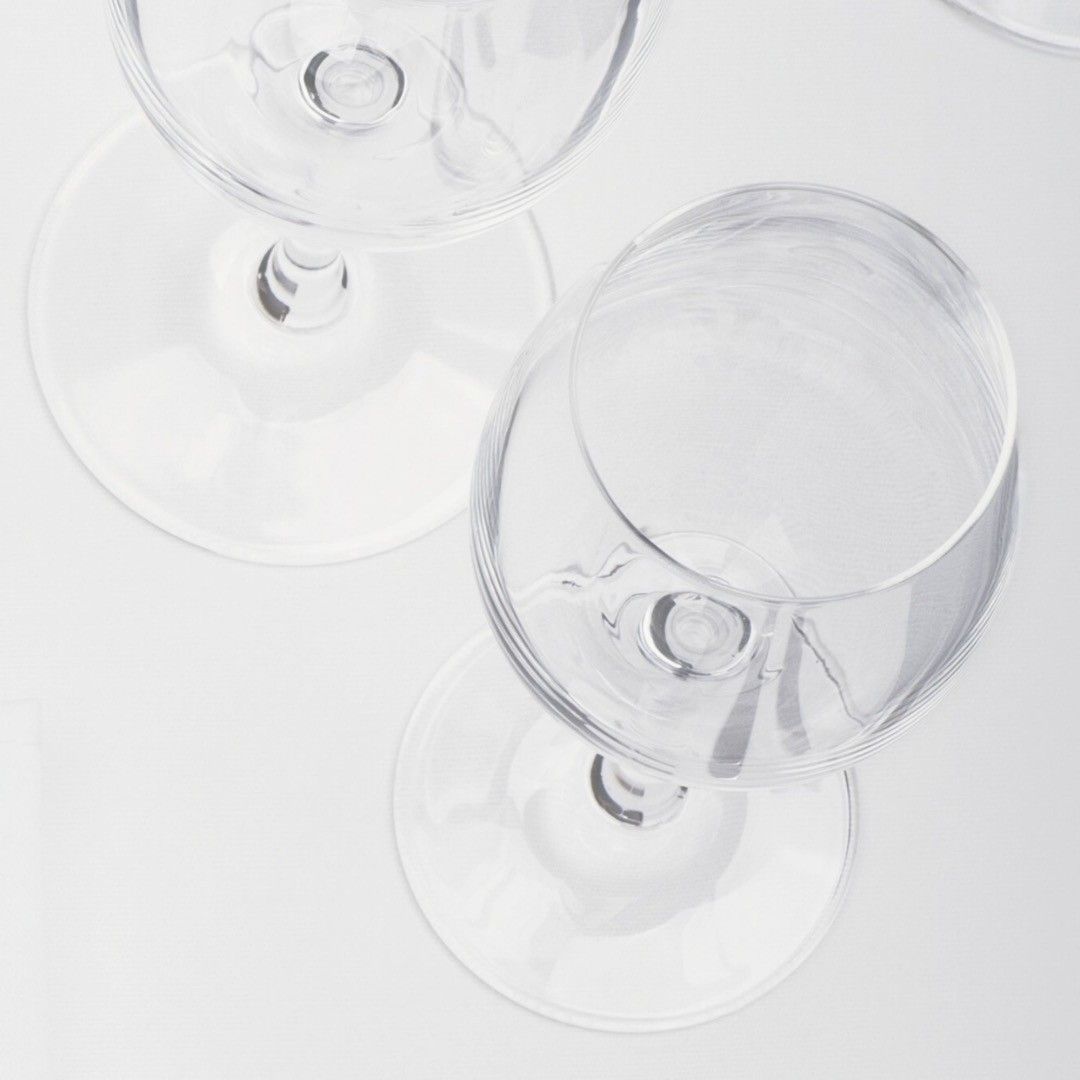 Tre bicchieri di vino sono appoggiati su un tavolo bianco.