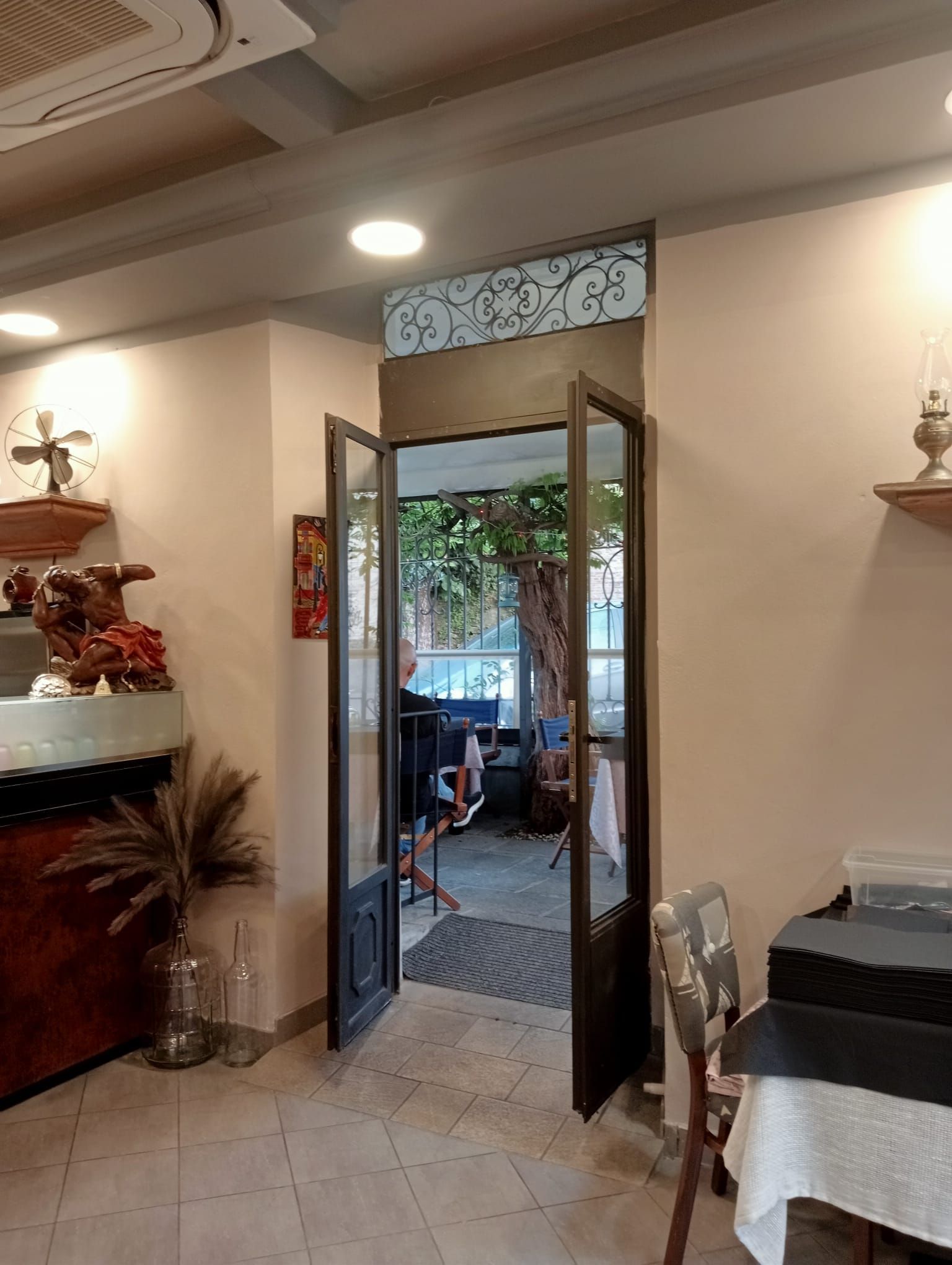 Una stanza con un tavolo, delle sedie e una porta aperta.