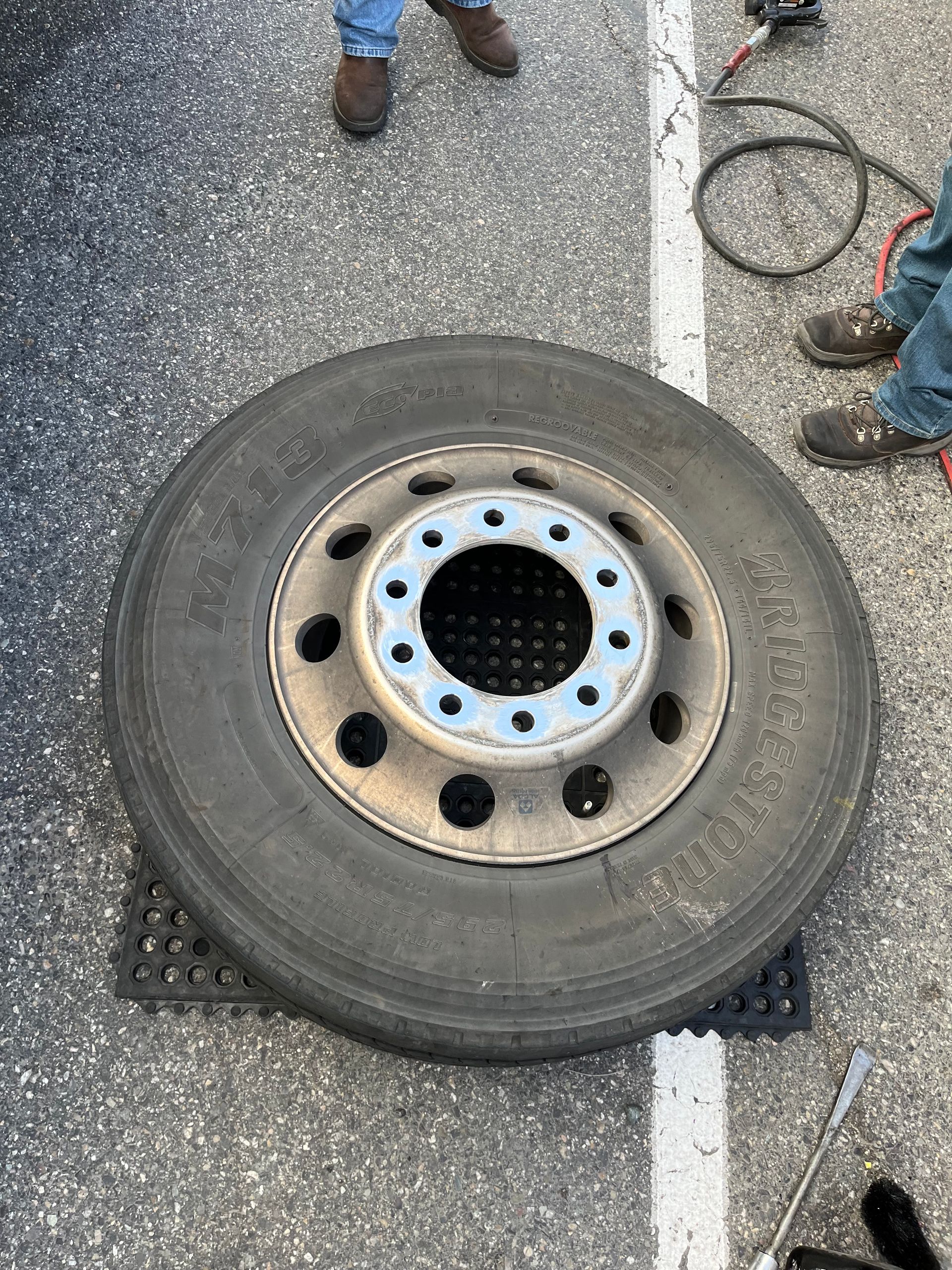 A tire is sitting on the ground next to a person.