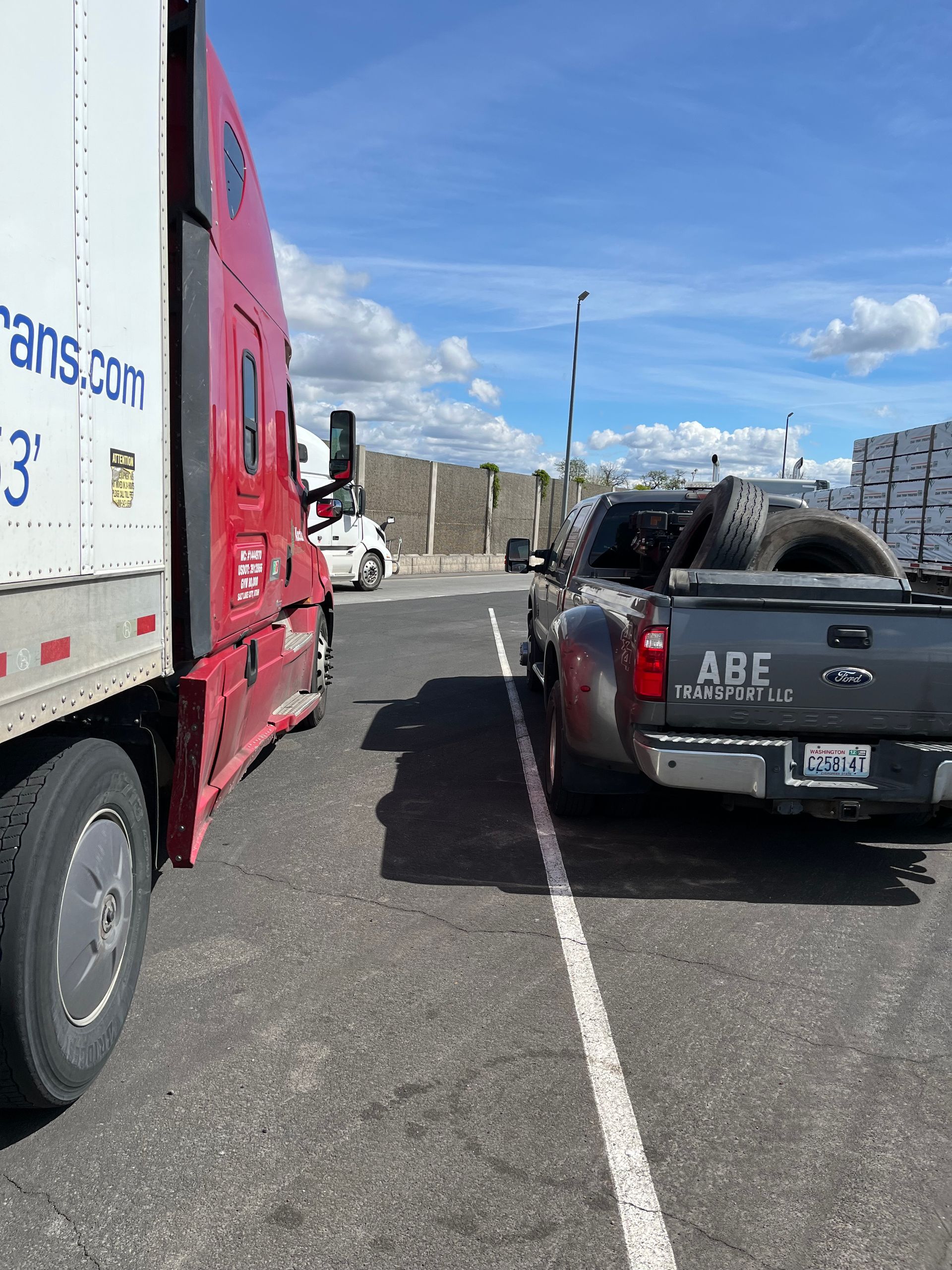 A truck and a pickup truck are parked in a parking lot.