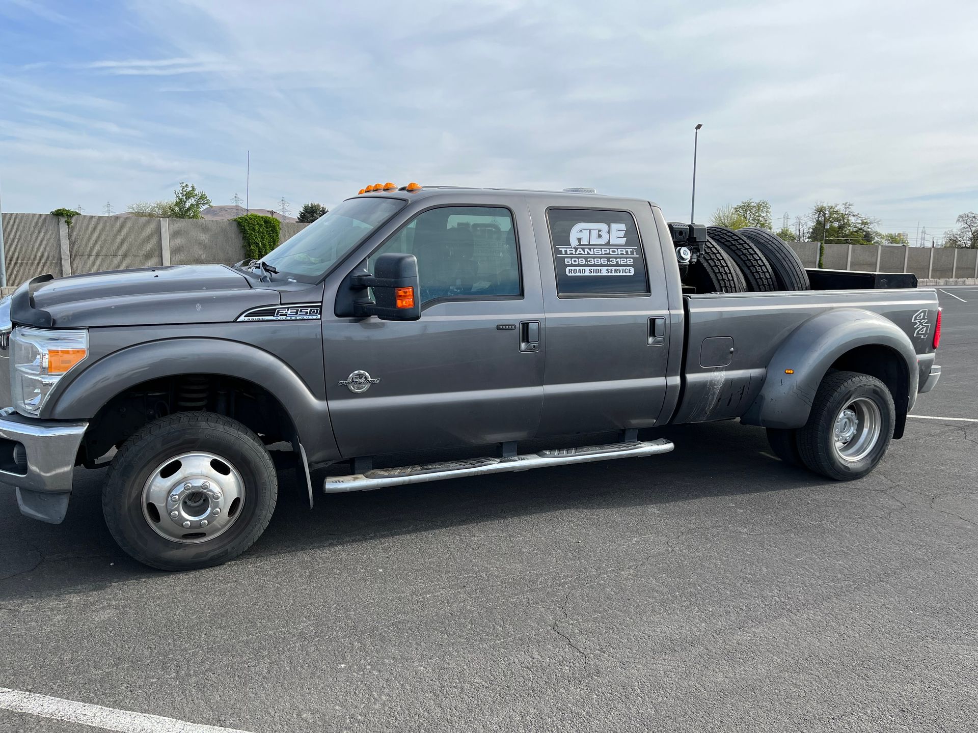 A gray tow truck is parked in a parking lot.