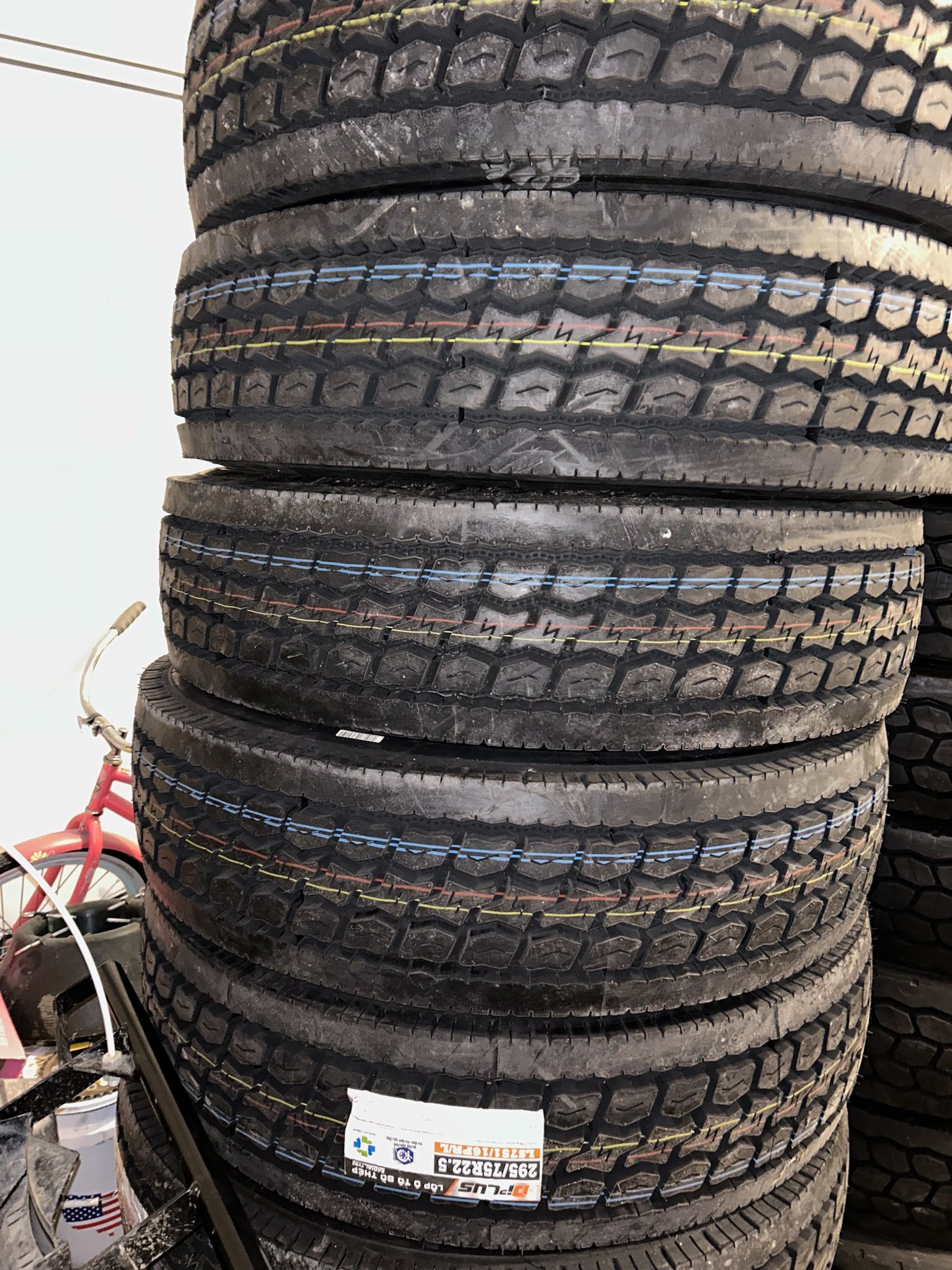 A pile of tires stacked on top of each other in a garage.