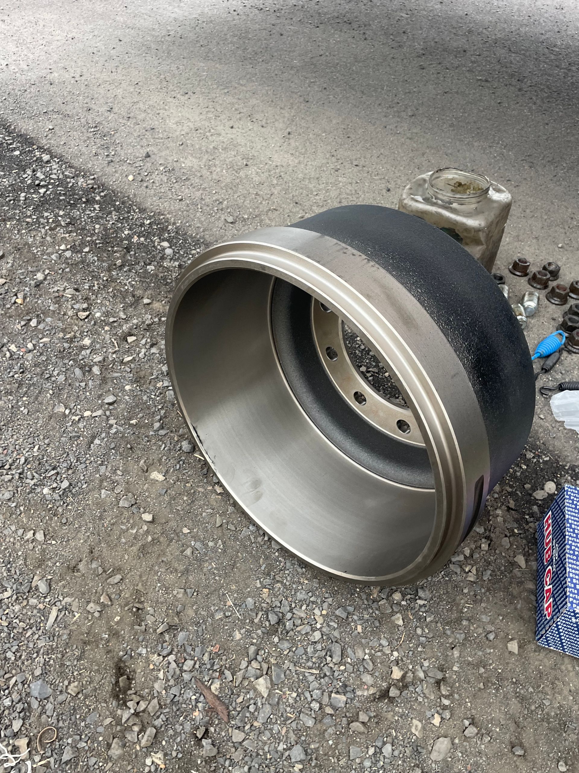 A close up of a brake drum on the ground.