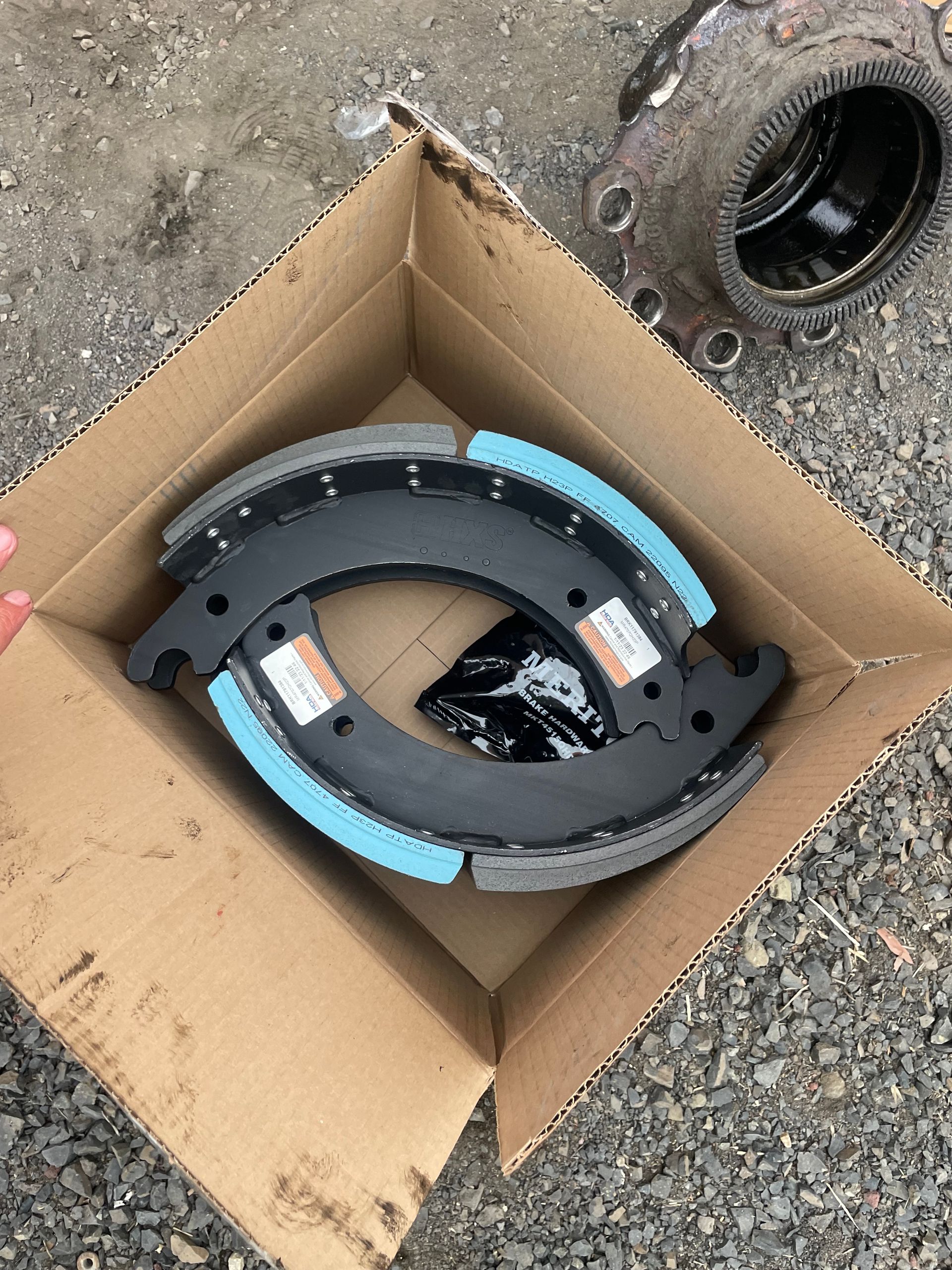 A pair of brake shoes are in a cardboard box.