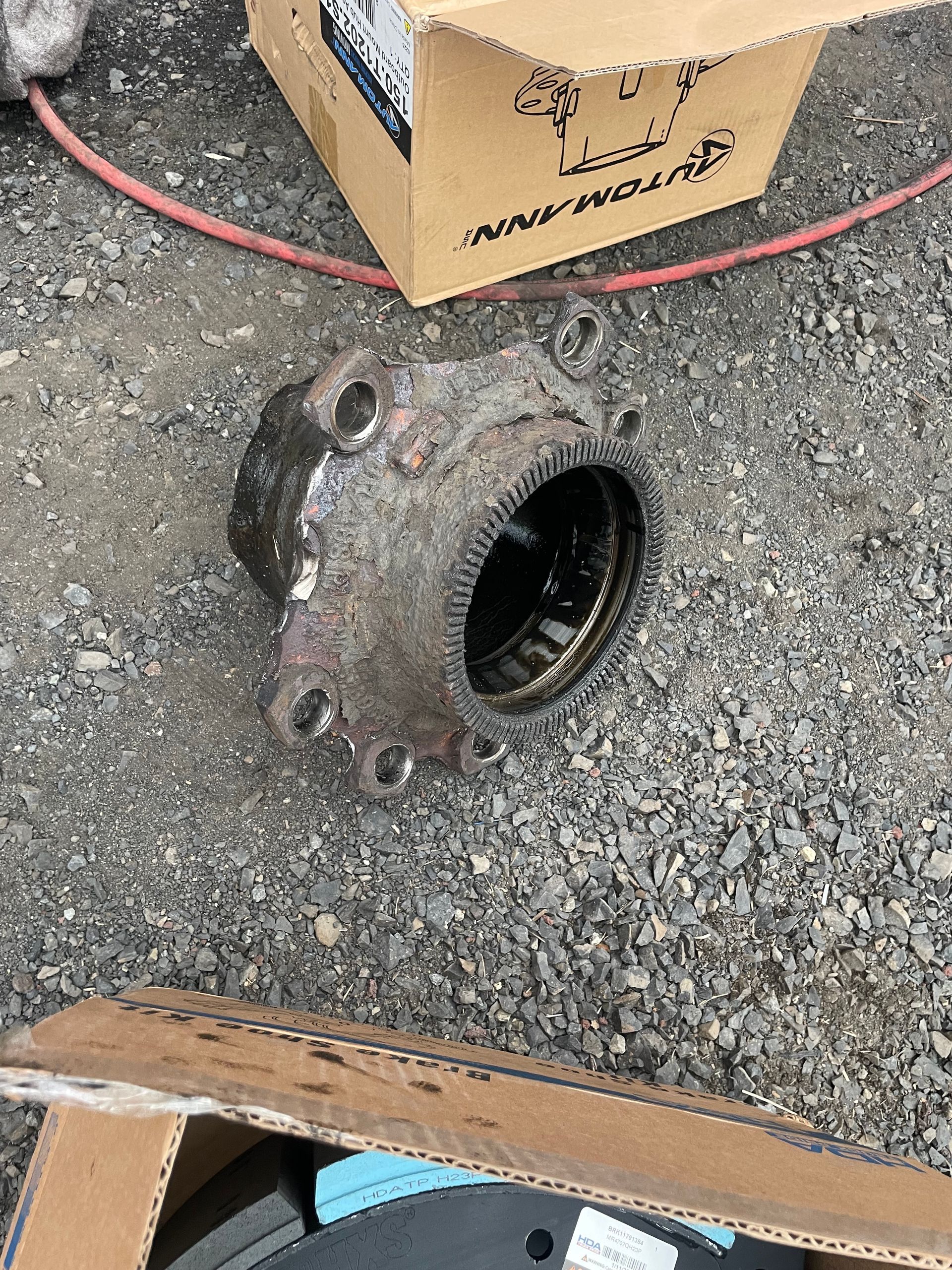 A piece of metal is sitting on the ground next to a cardboard box.