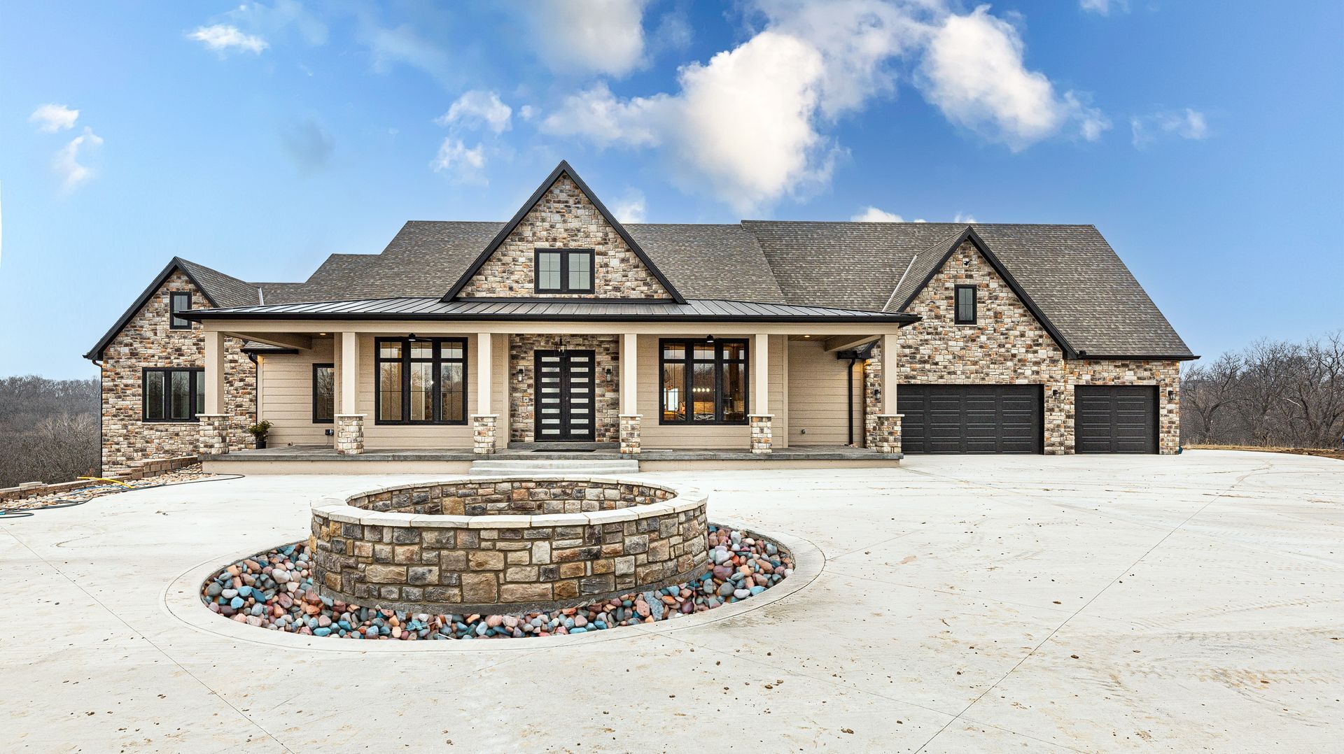 A large house with a fire pit in front of it.