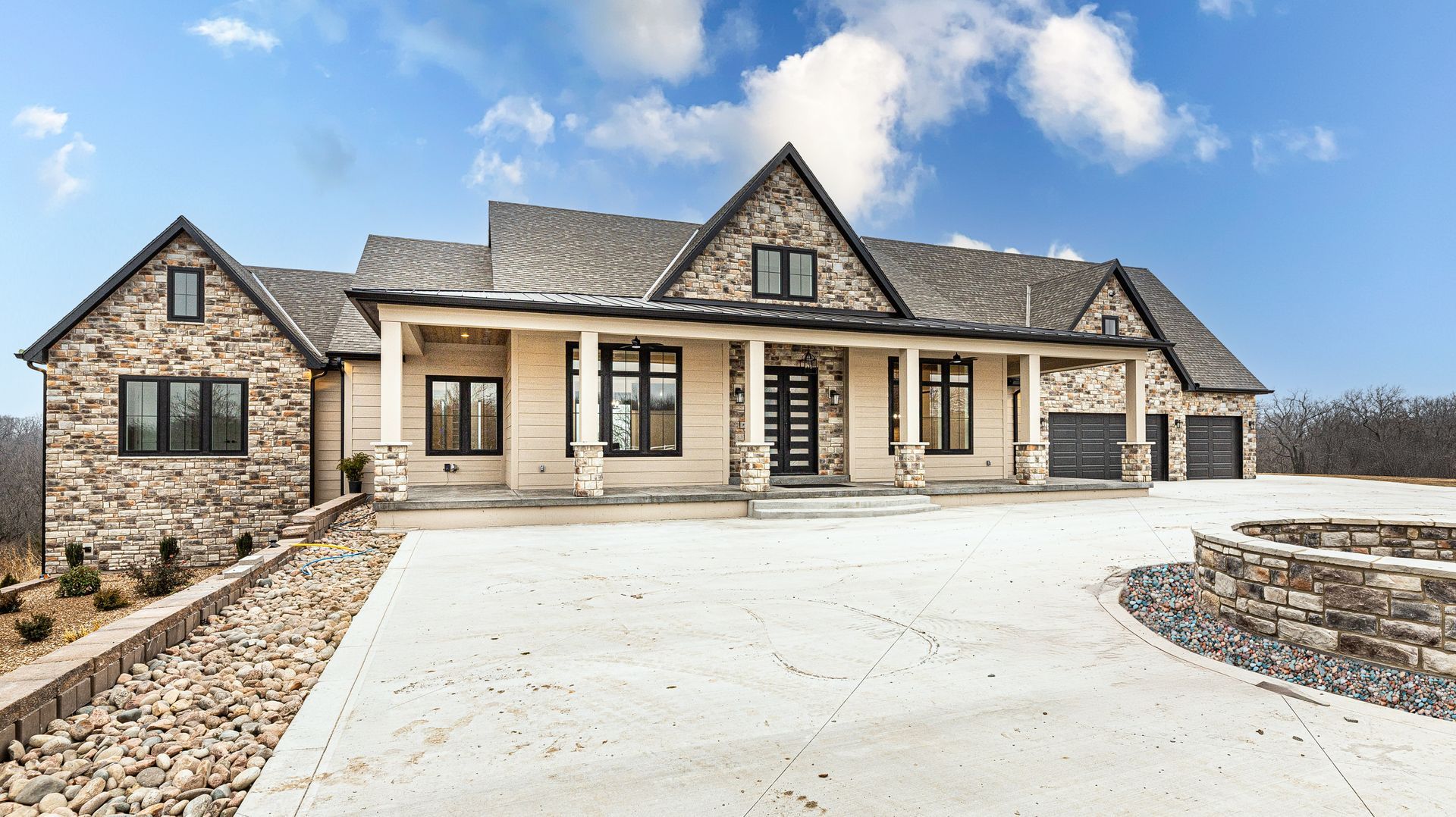 A large stone house with a driveway in front of it