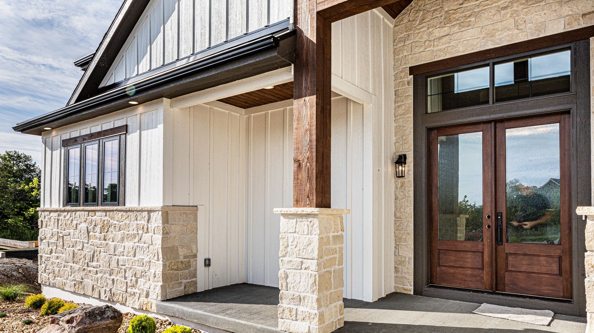 The front of a house with a large porch and a wooden door.