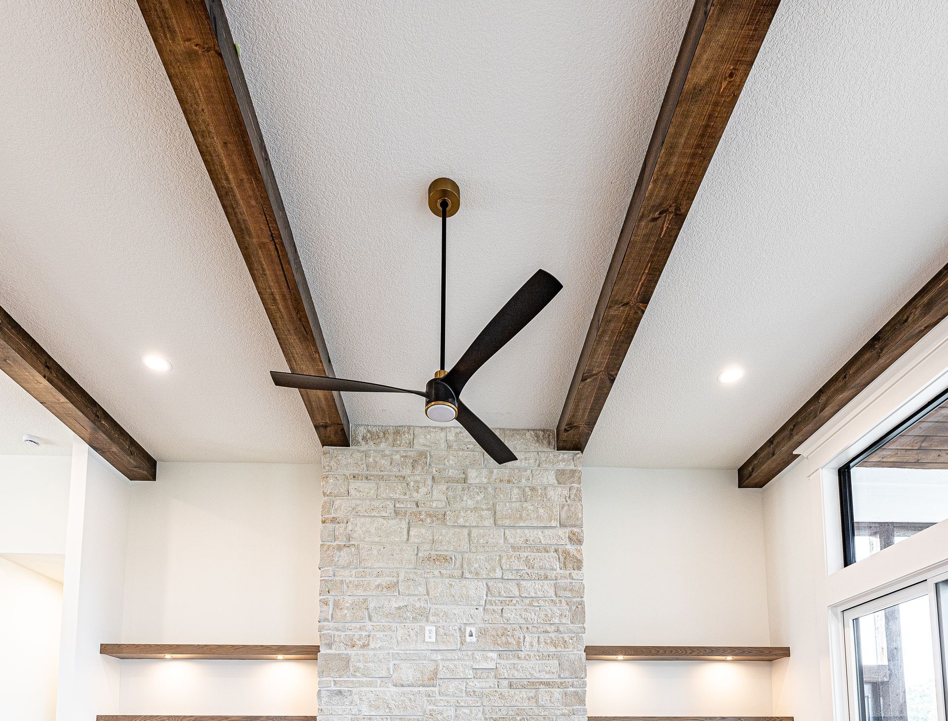 A ceiling fan is hanging from the ceiling of a living room.