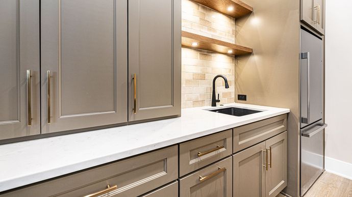 A kitchen with stainless steel appliances , a sink , and a refrigerator.