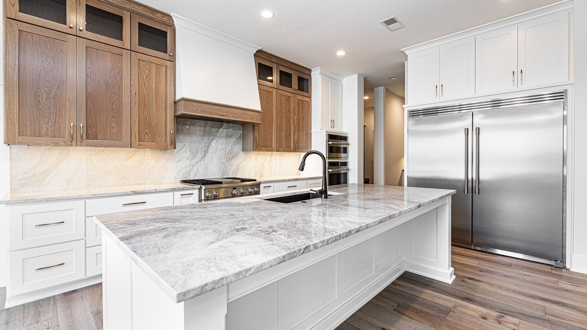 A kitchen with granite counter tops and stainless steel appliances.
