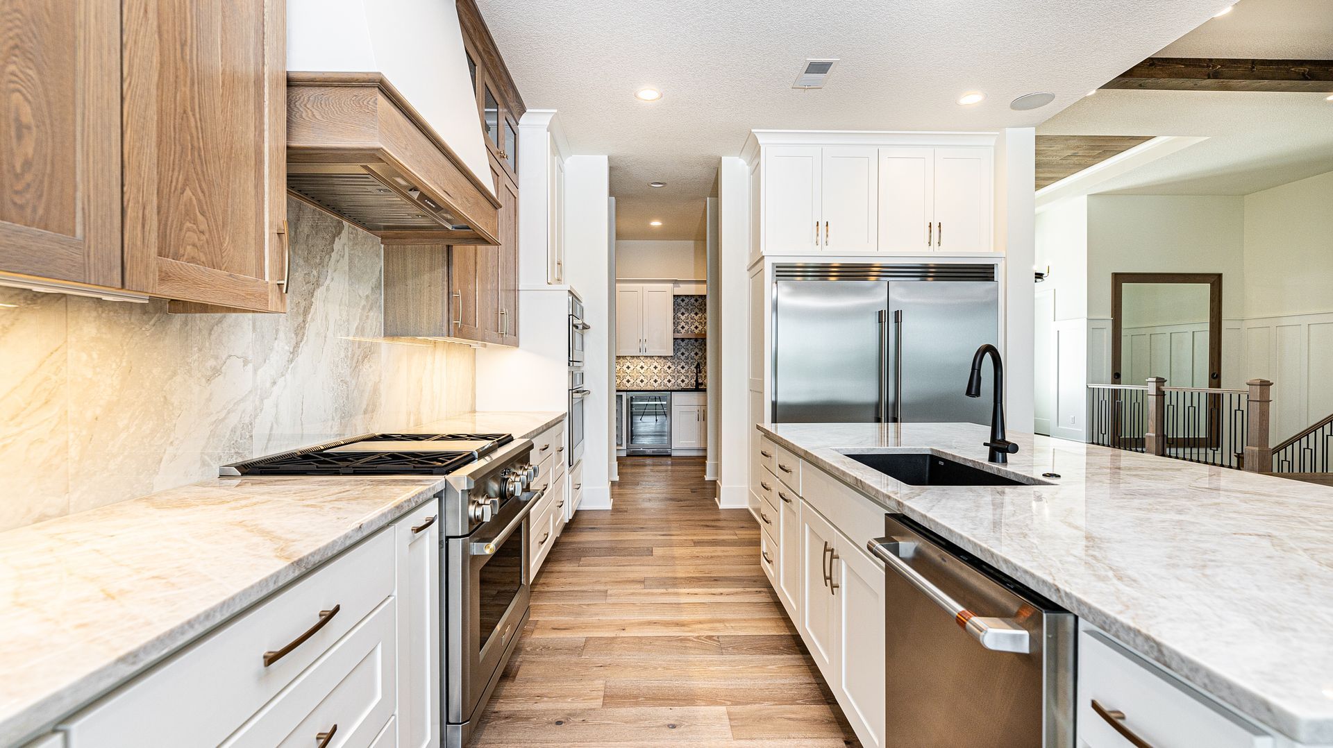 A kitchen with white cabinets , stainless steel appliances and granite counter tops.