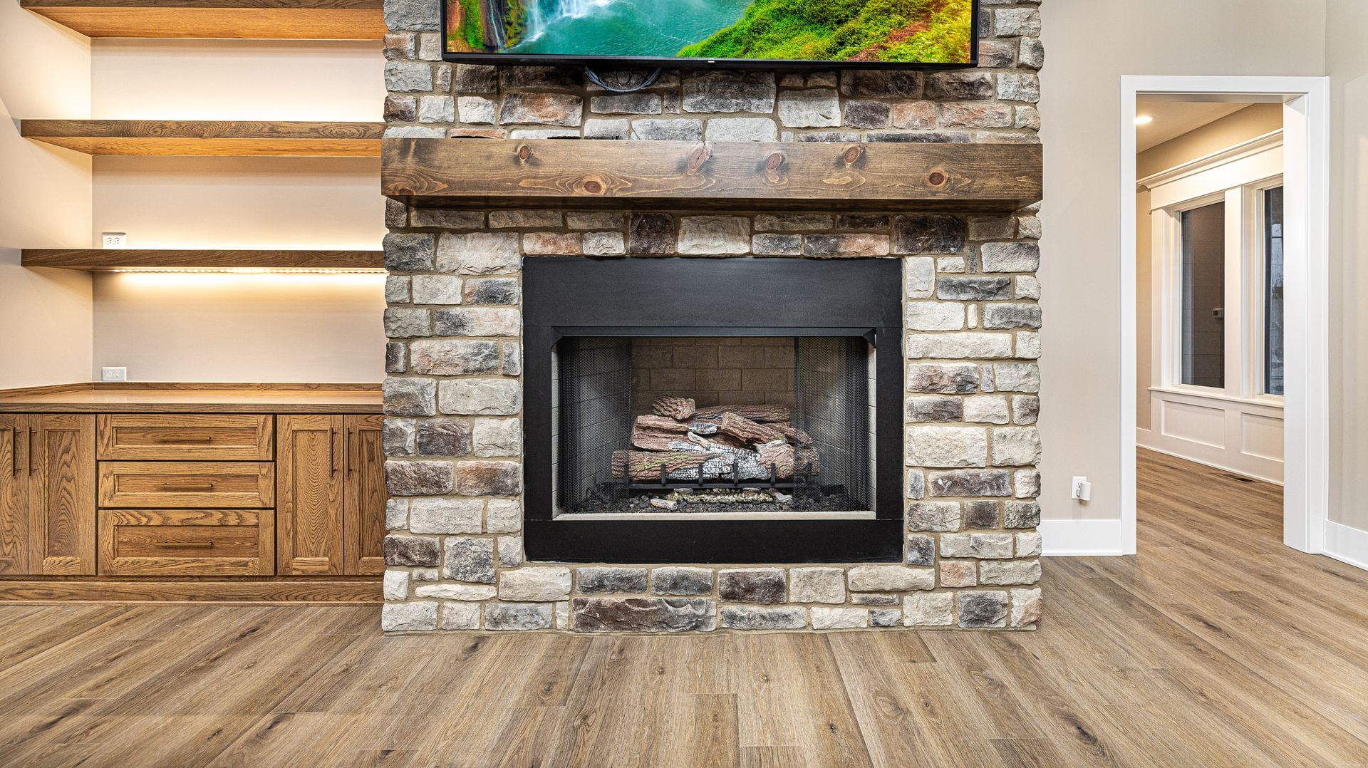 A living room with a fireplace and a flat screen tv.