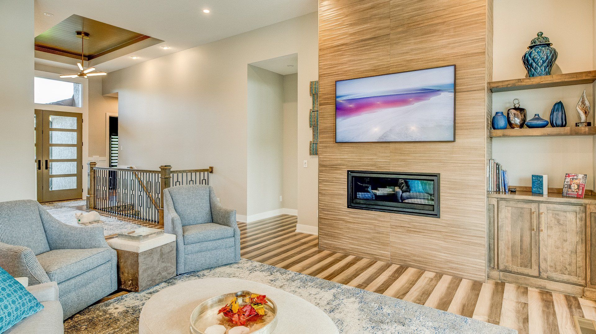 A living room with a fireplace and a flat screen tv on the wall.