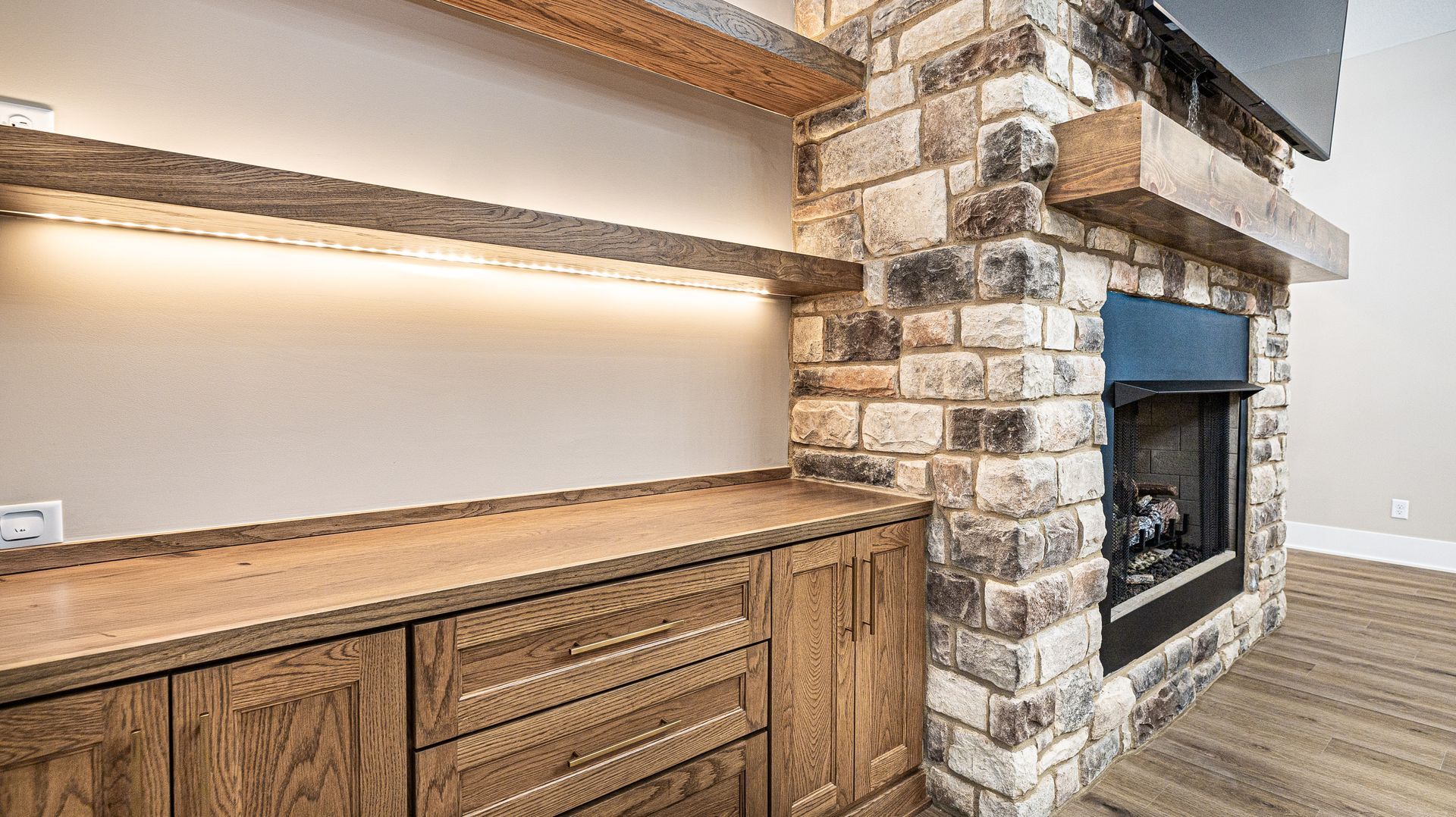 A living room with a fireplace and wooden cabinets.