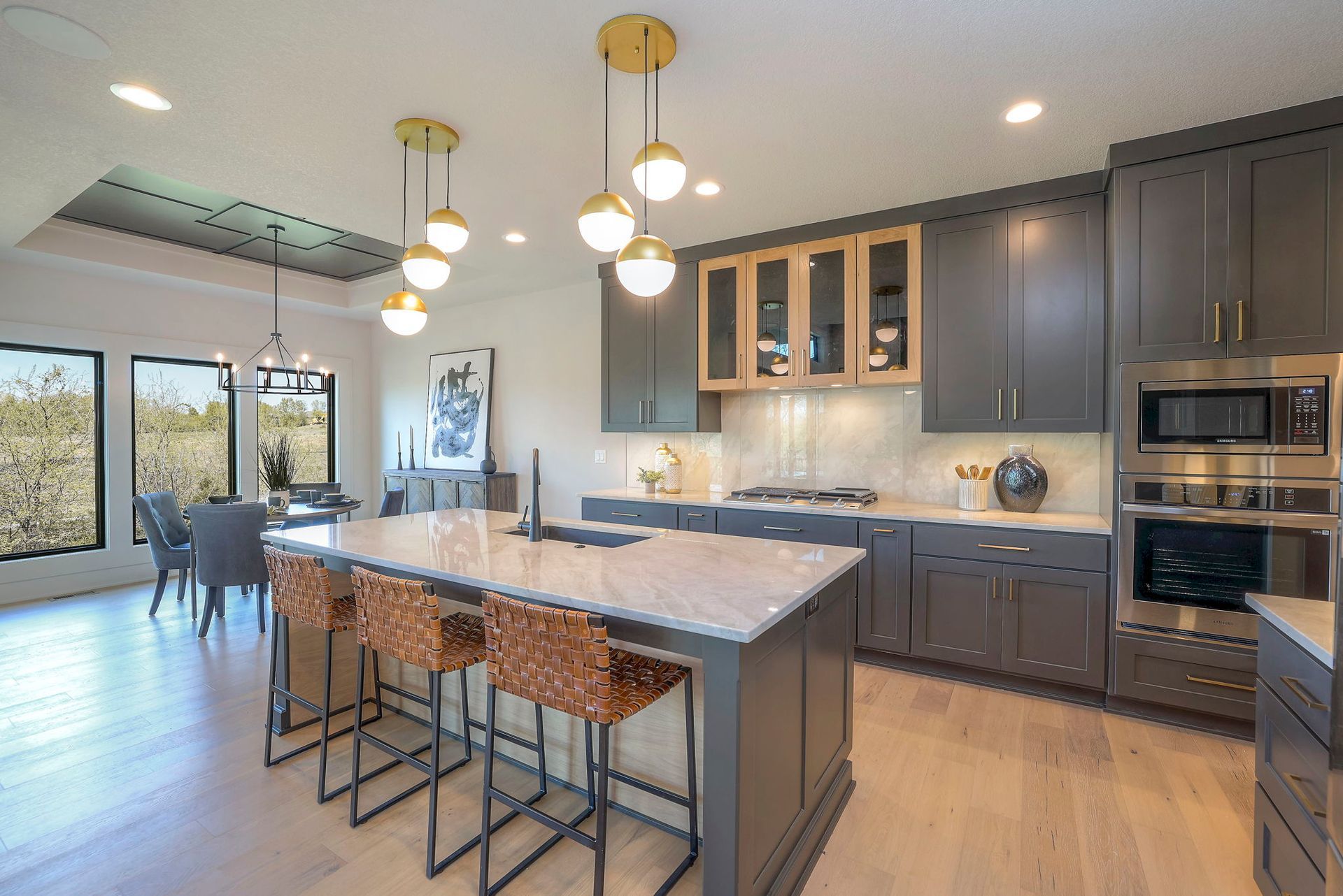 A kitchen with gray cabinets and a large island in the middle.