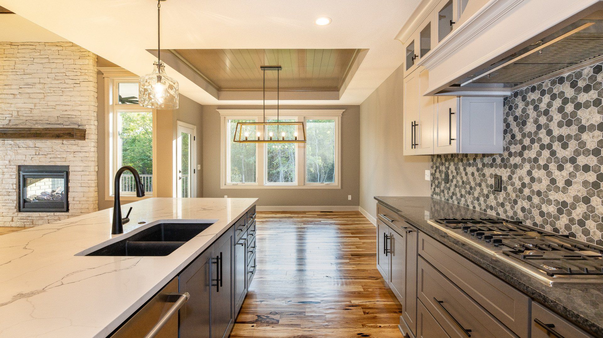 A kitchen with two sinks , a stove , and a fireplace.