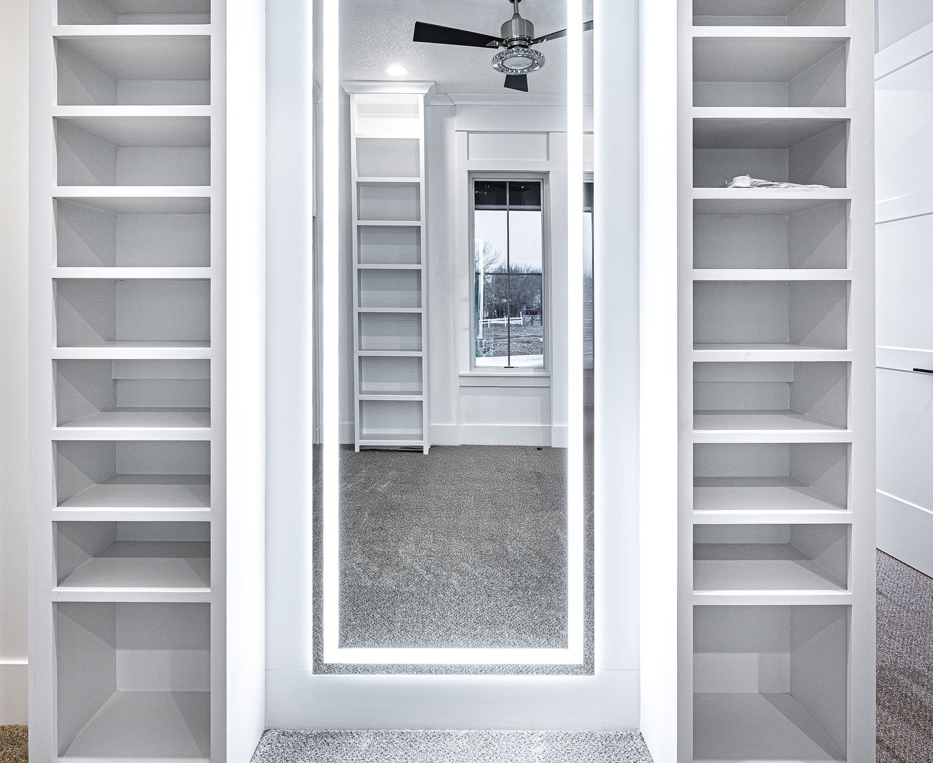 A walk in closet with shelves and a mirror