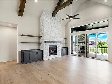A living room with a fireplace and a ceiling fan.