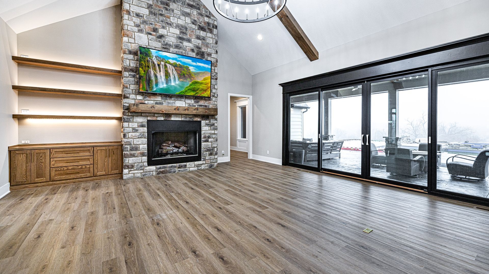 A living room with hardwood floors , a fireplace and a flat screen tv.