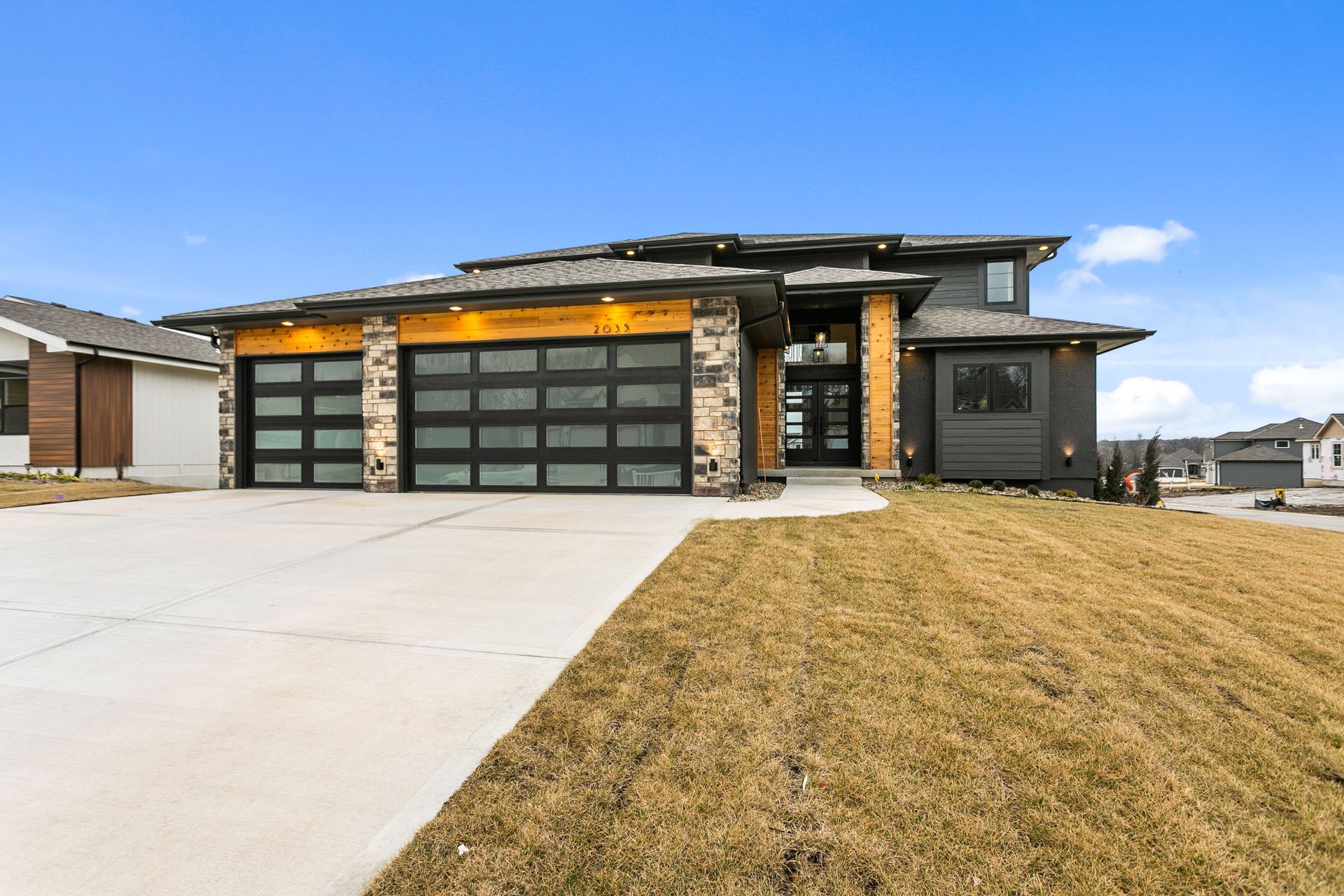 A large house with a large garage door and a concrete driveway.