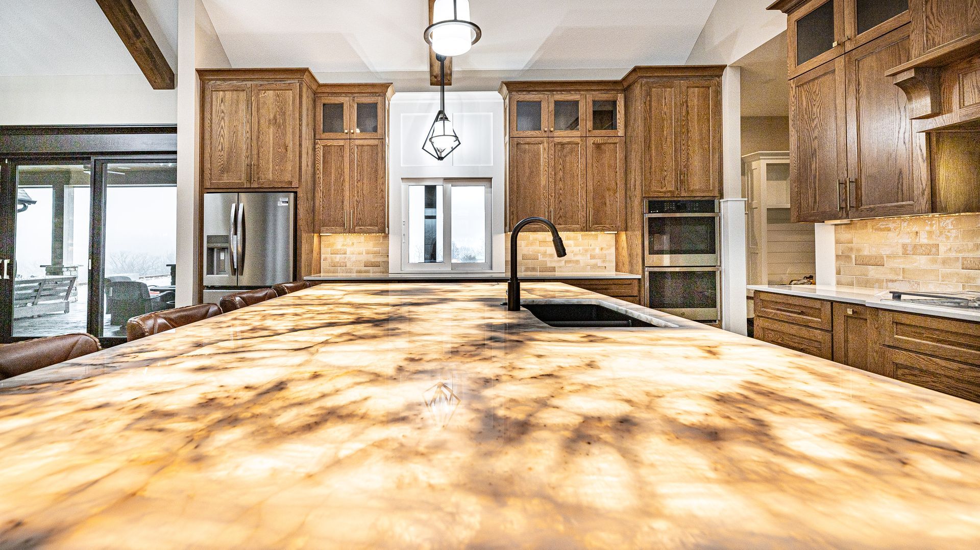A kitchen with a large granite counter top and wooden cabinets.