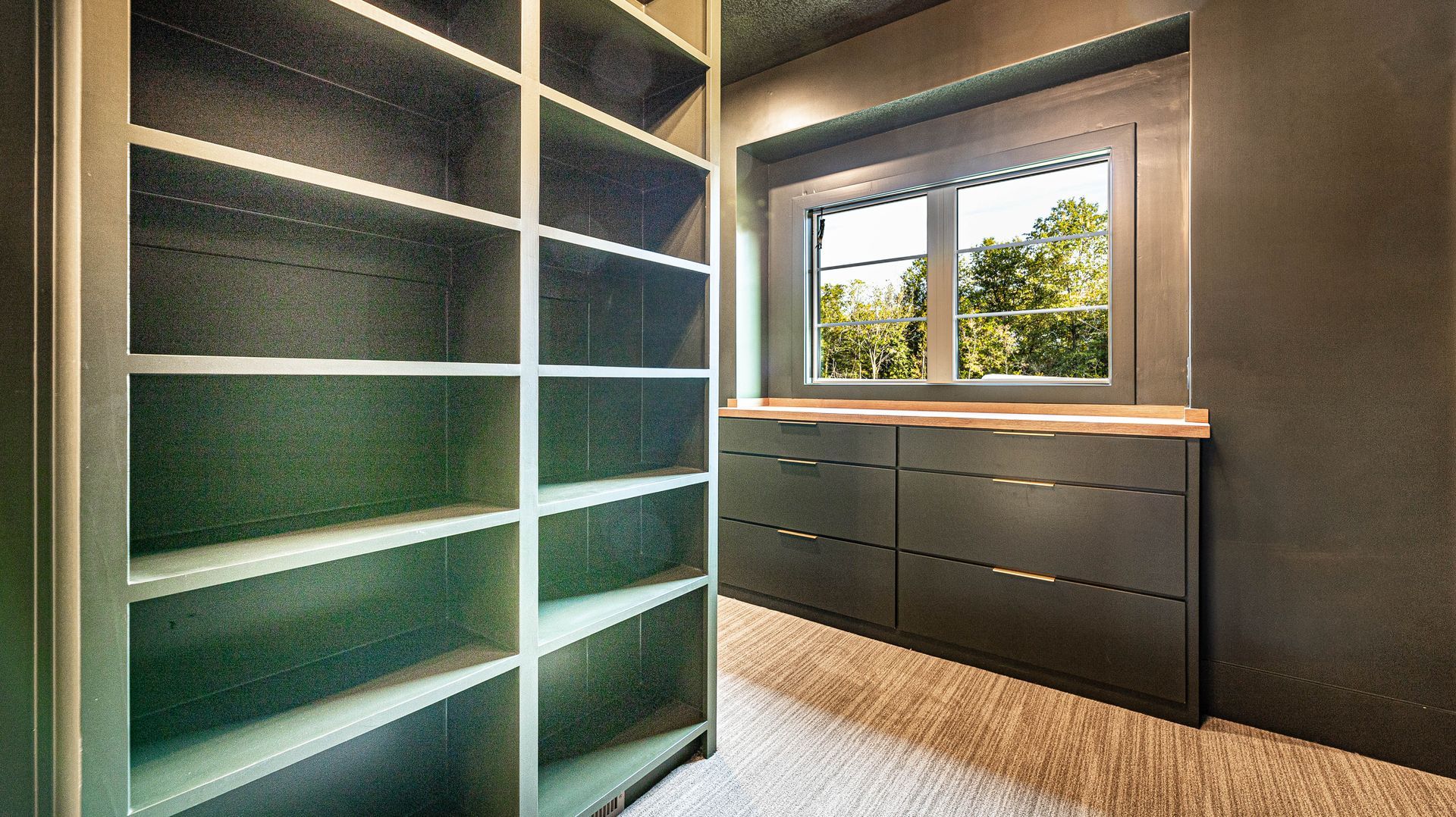 A walk in closet with lots of shelves and a window