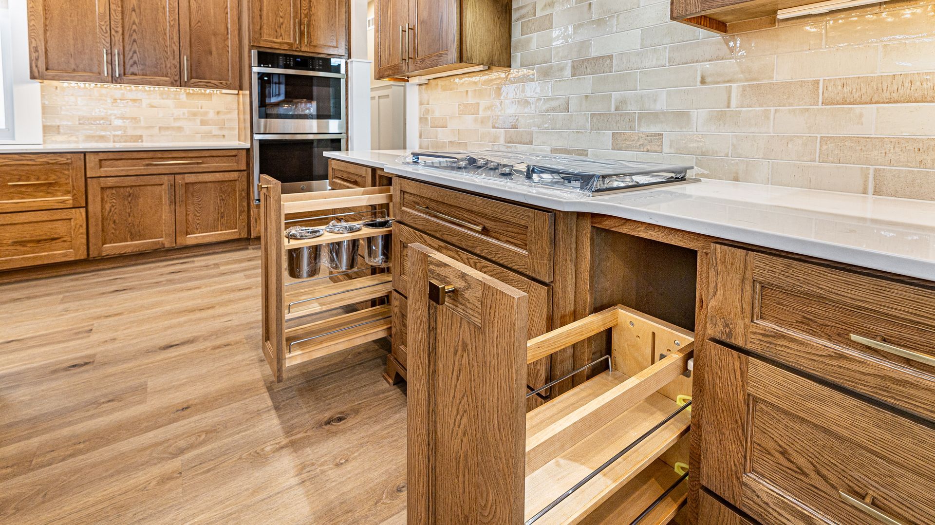 A kitchen with wooden cabinets and drawers and a stove top oven.