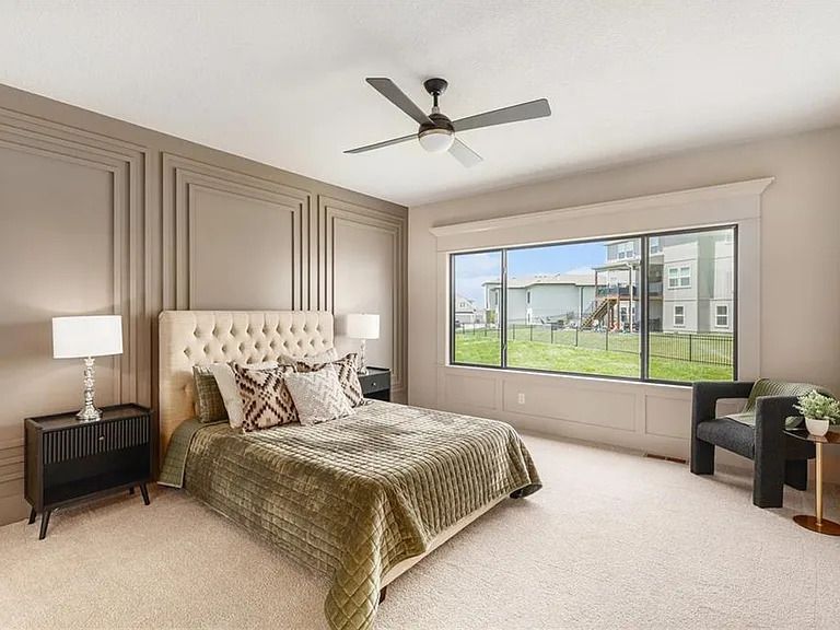 A bedroom with a large bed and a ceiling fan.