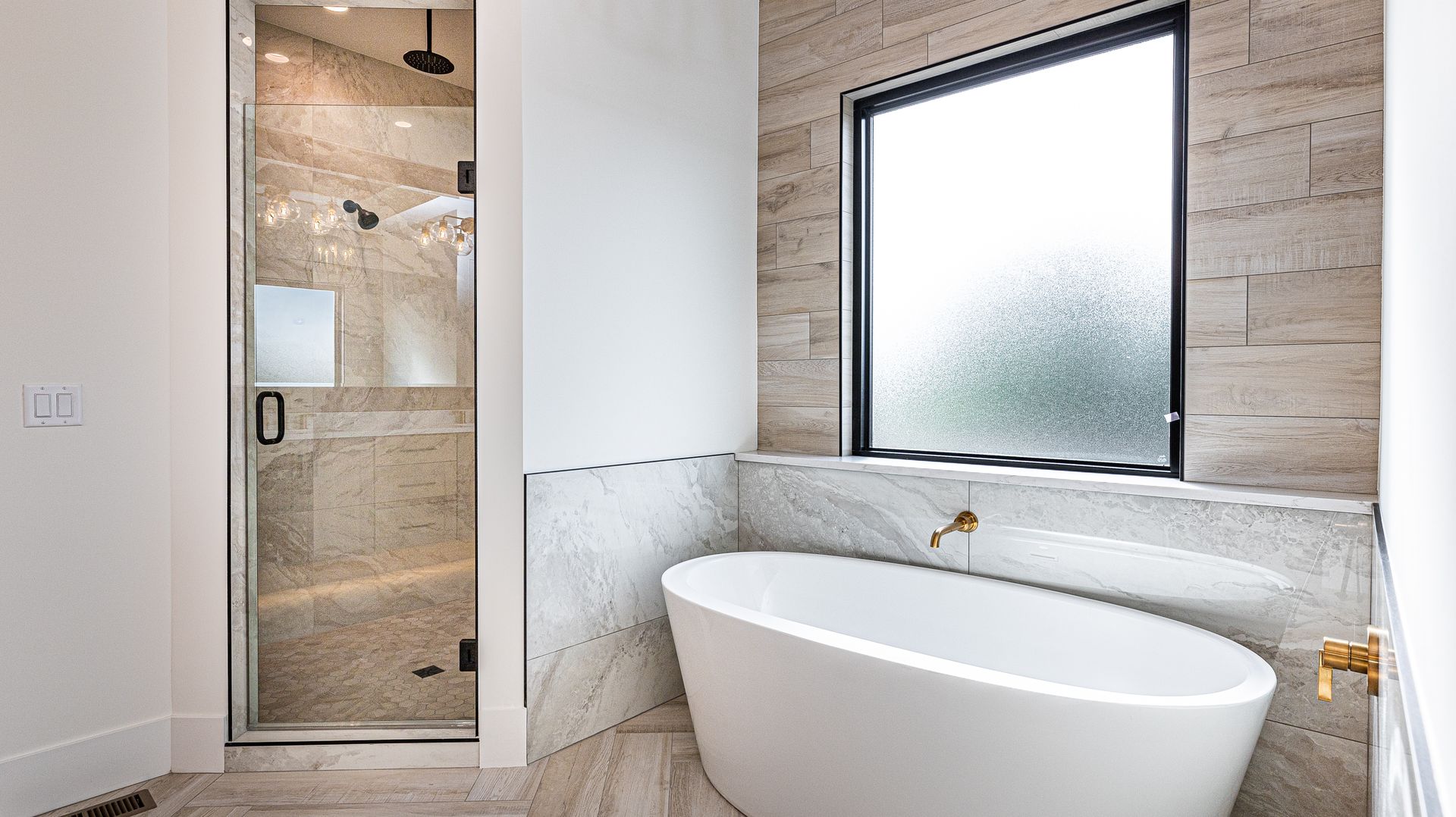 A bathroom with a tub , shower , and window.