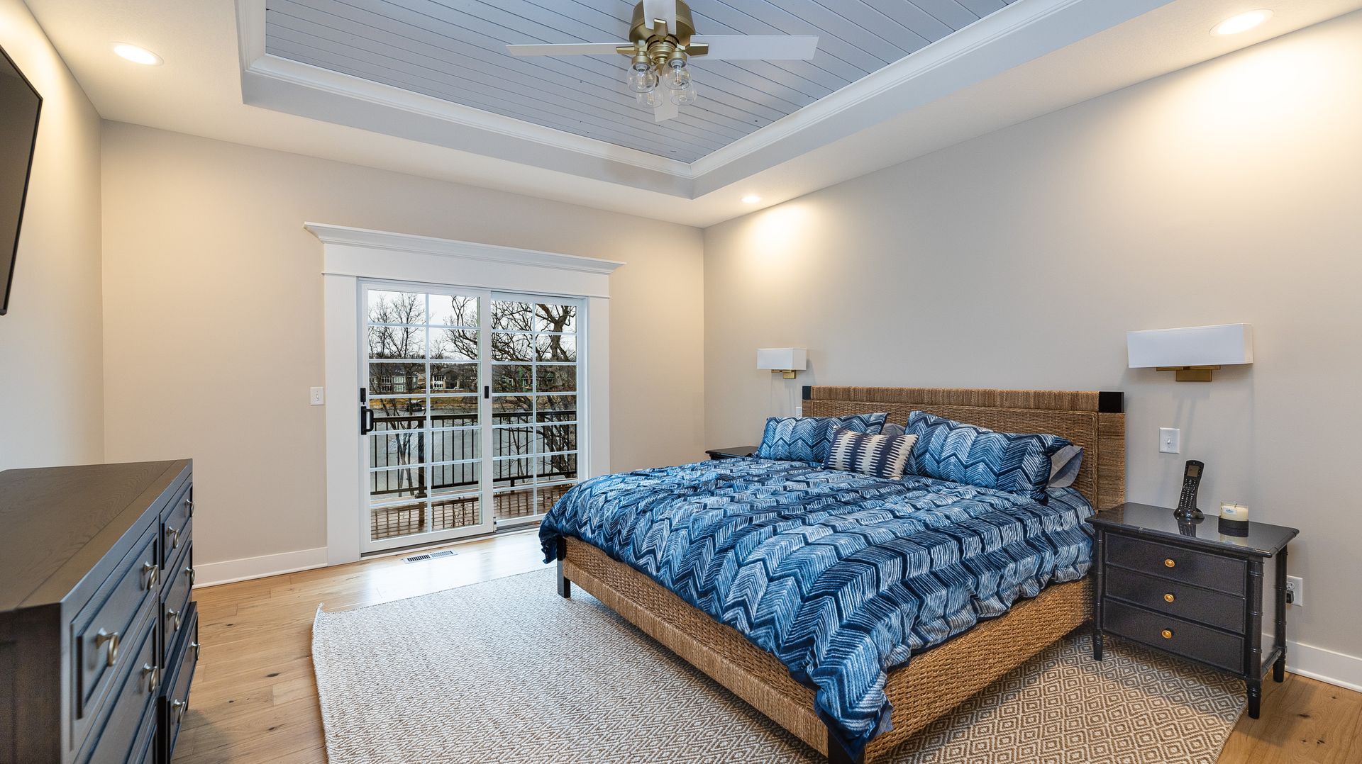 A bedroom with a large bed and a ceiling fan
