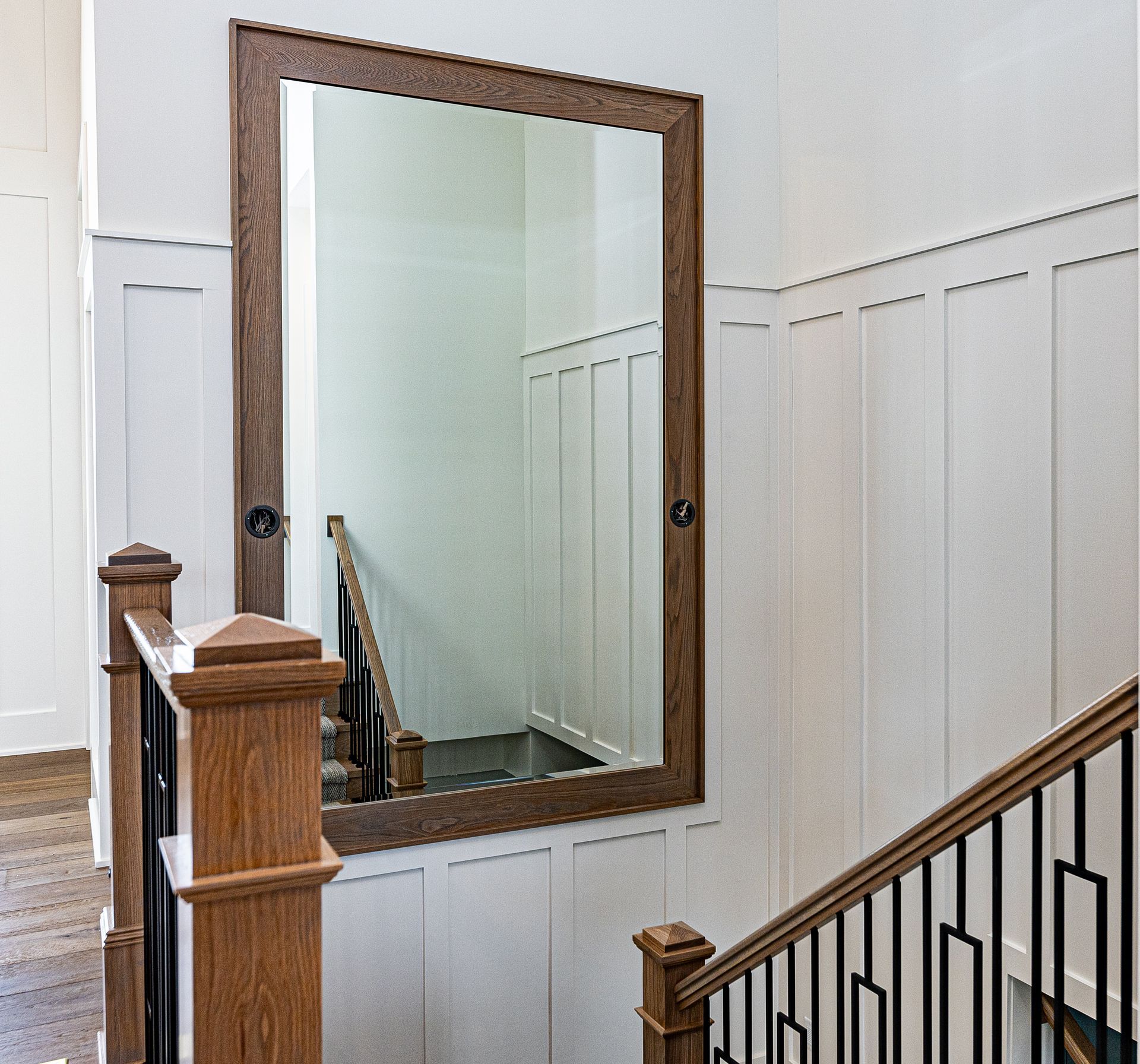 A staircase with a large mirror on the wall