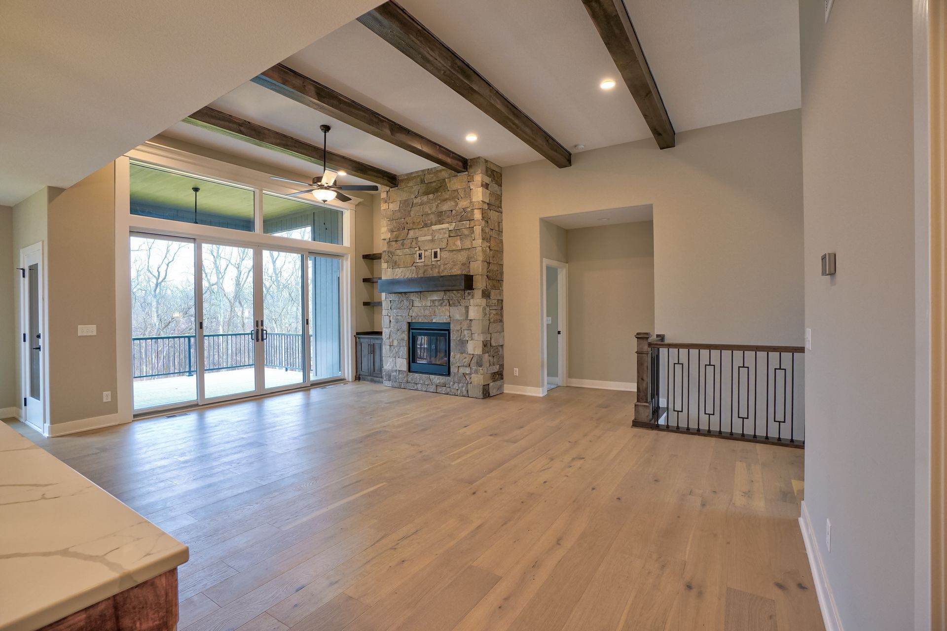 An empty living room with hardwood floors and a fireplace.