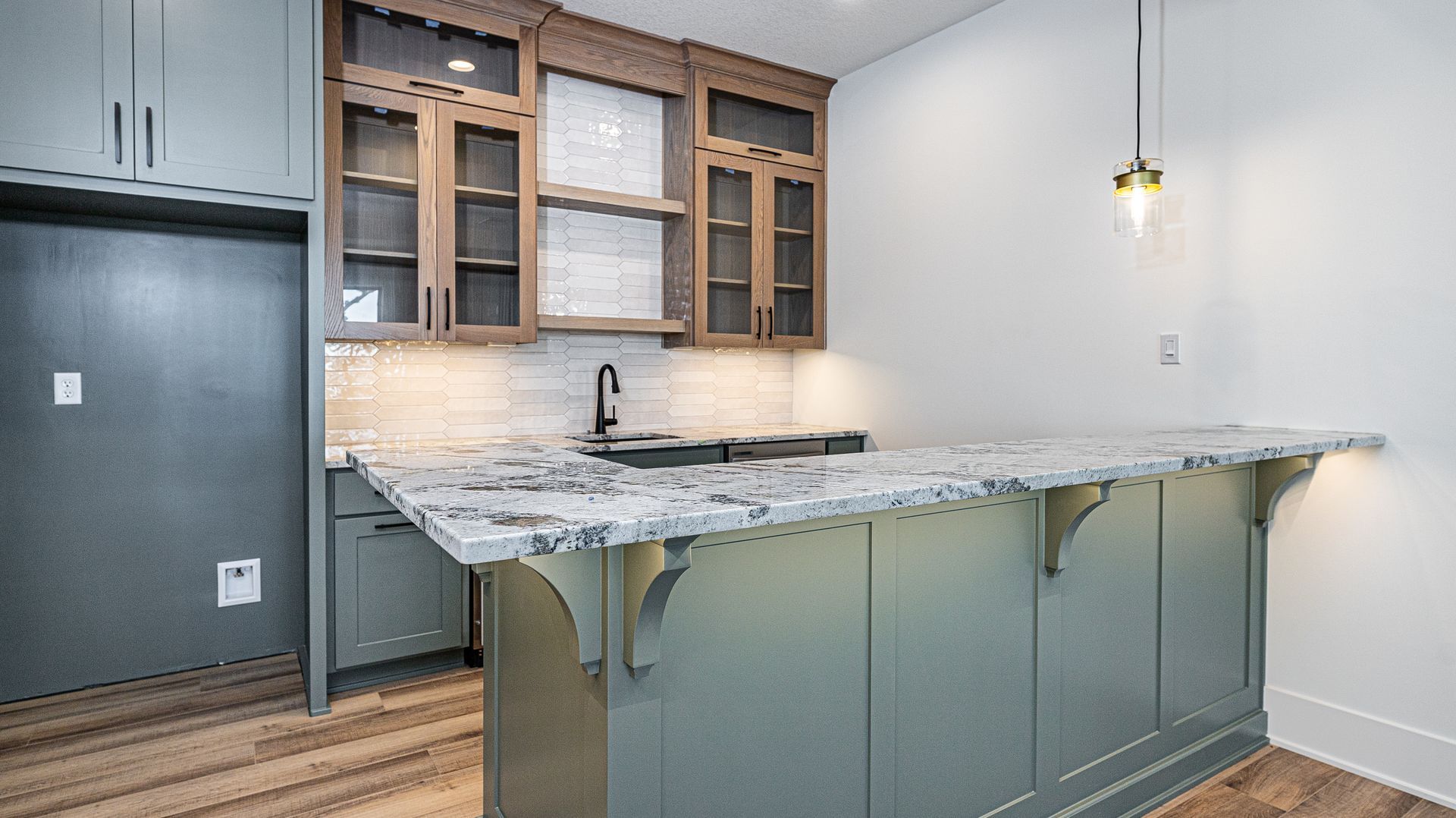 A kitchen with a large island and granite counter tops.