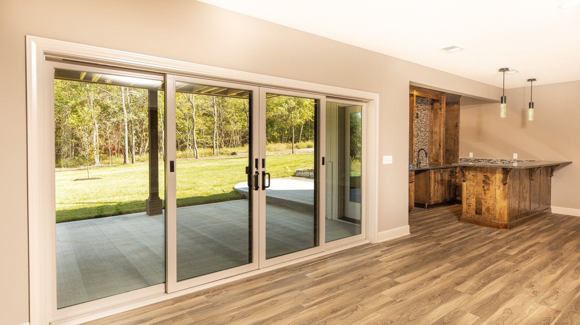 An empty room with sliding glass doors leading to a patio.