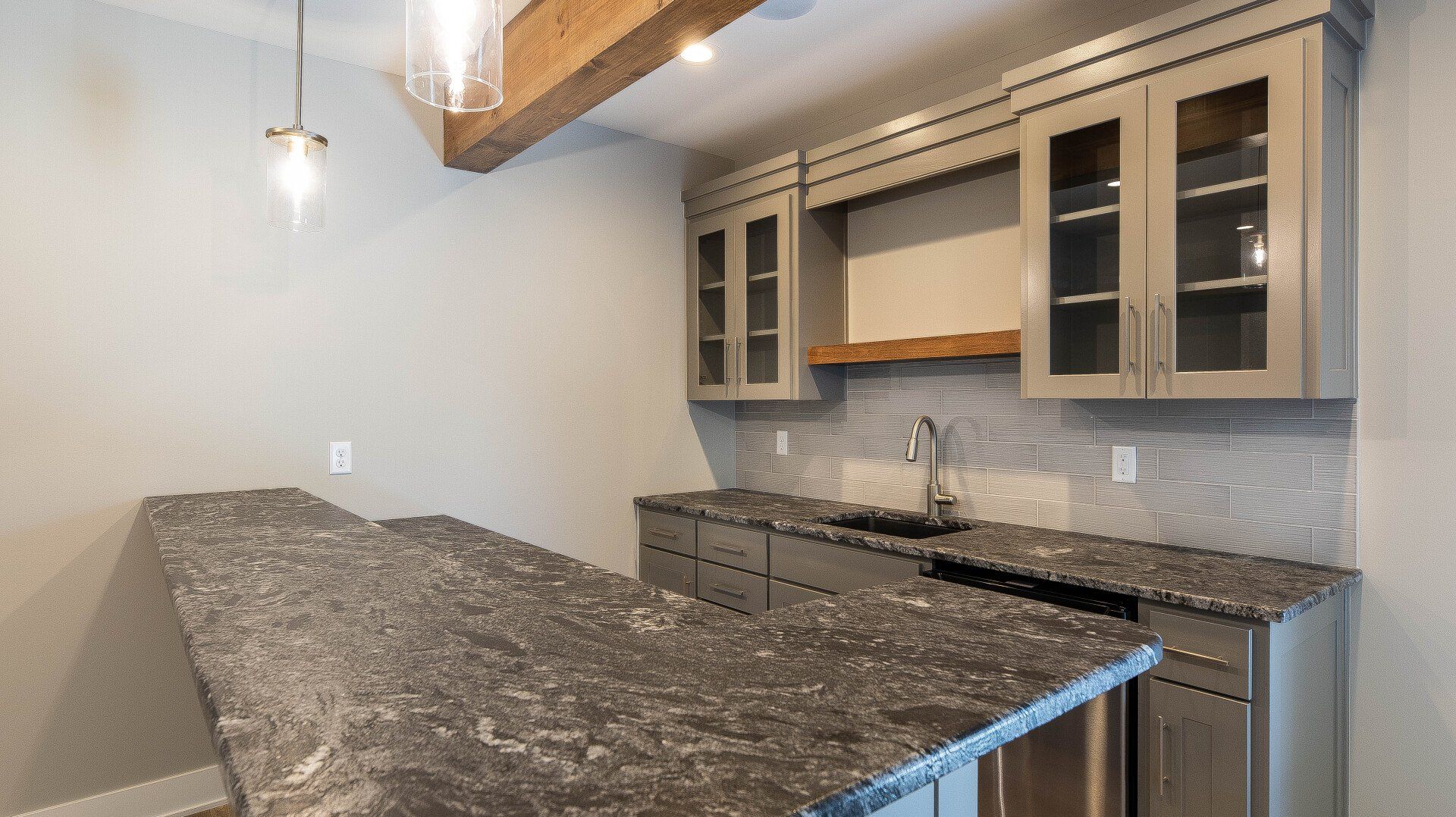 A kitchen with granite counter tops and stainless steel appliances.