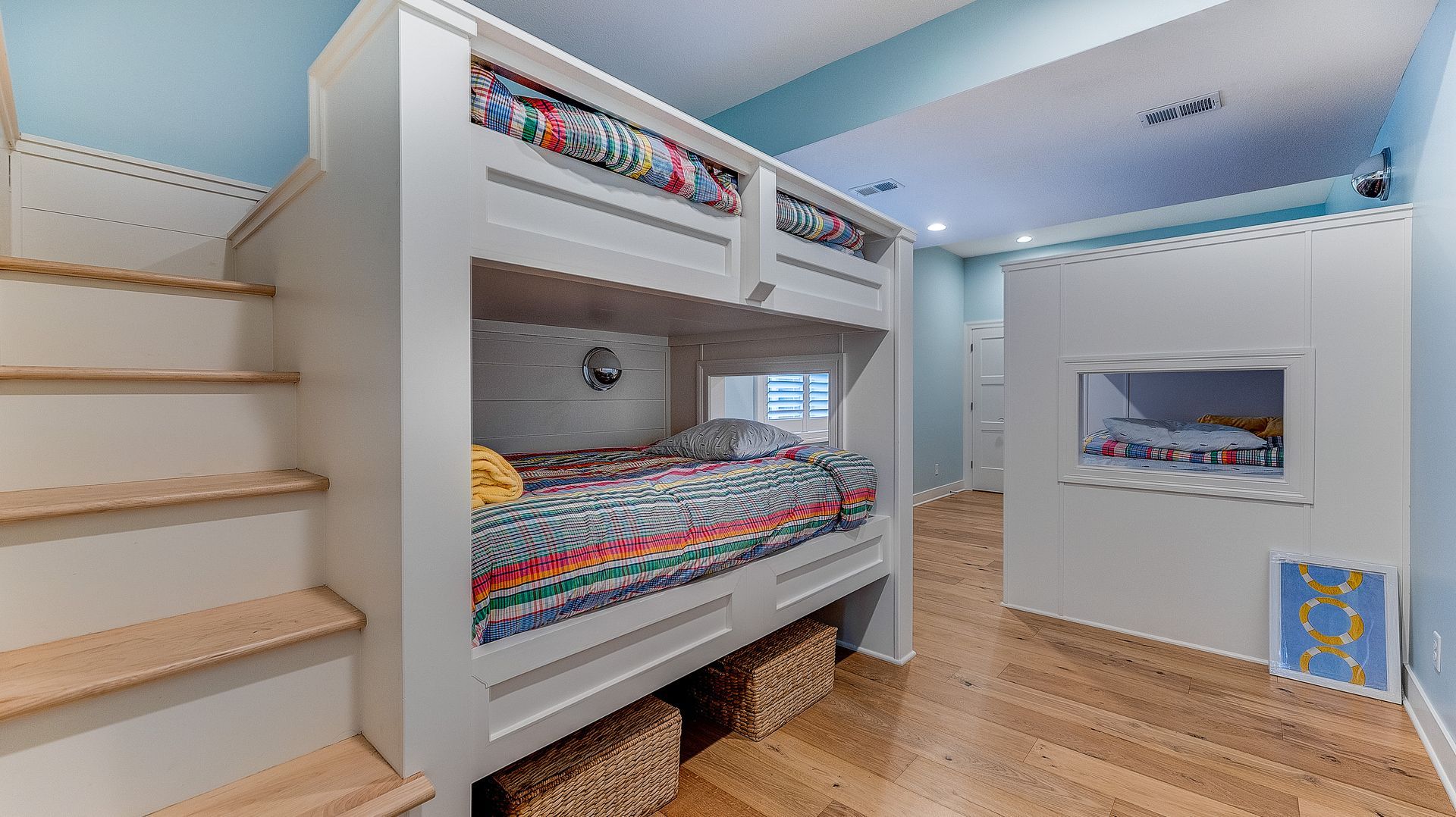 A bunk bed with stairs leading up to it in a room.