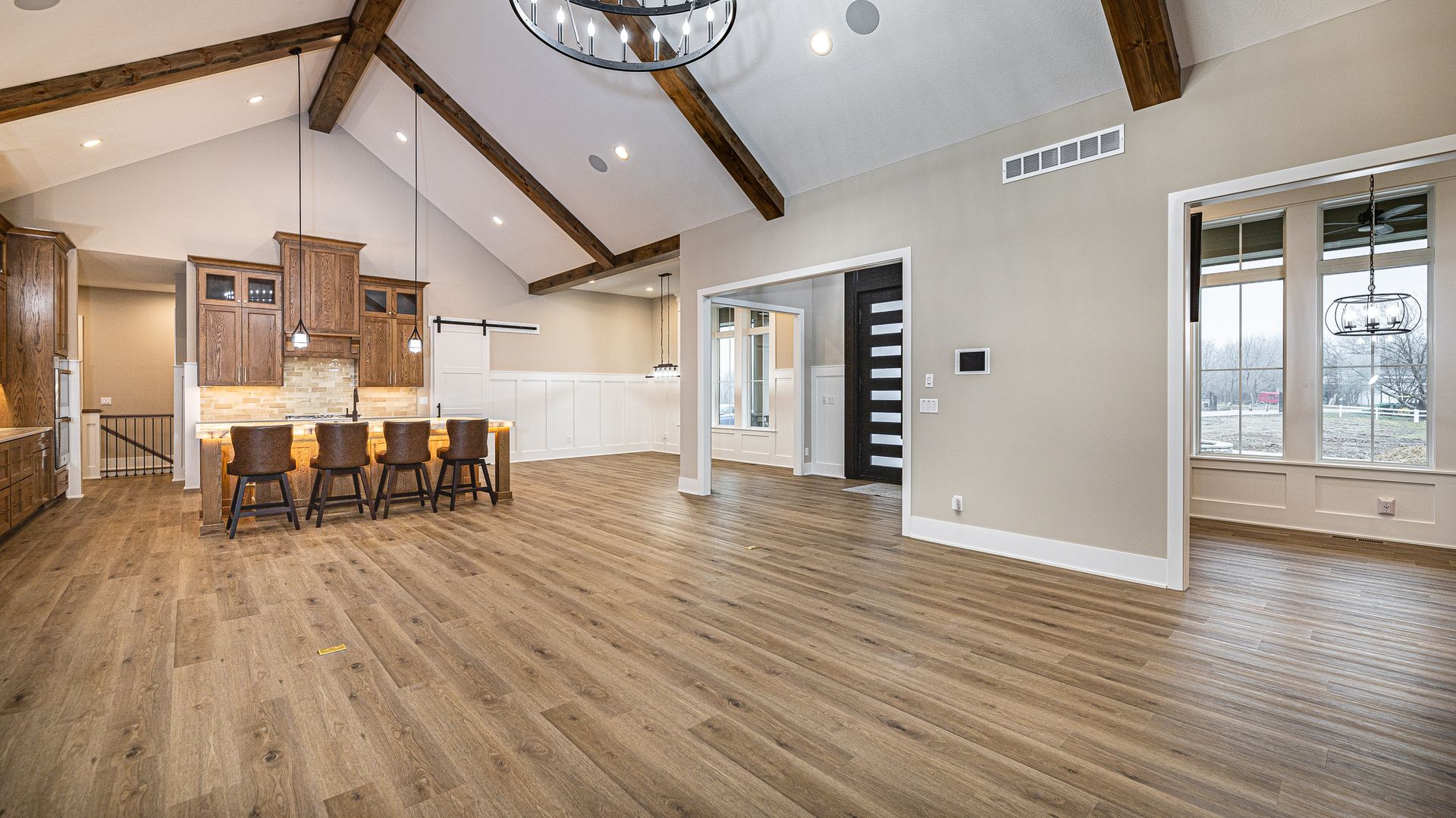 A large empty room with hardwood floors and a vaulted ceiling.