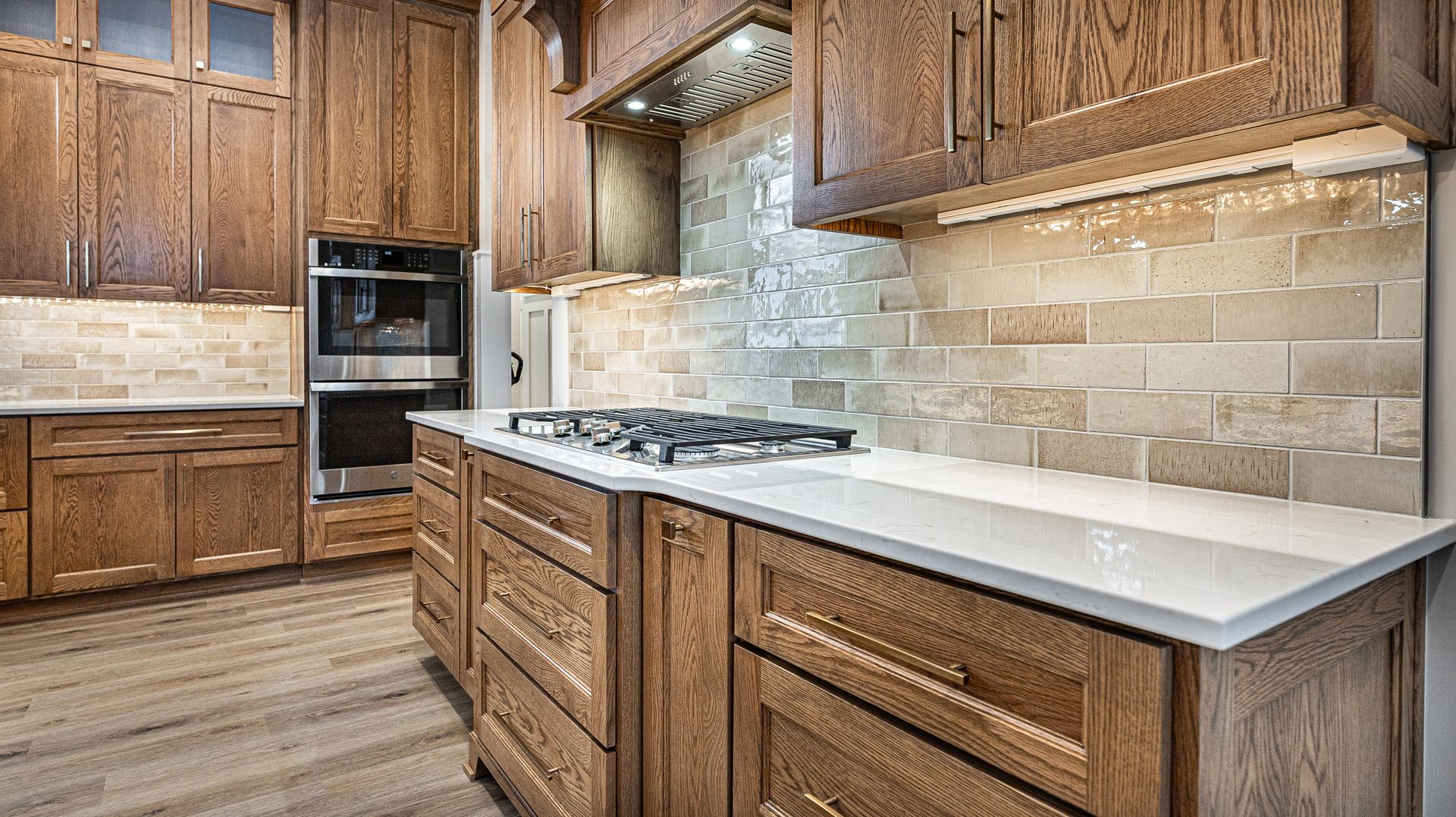 A kitchen with wooden cabinets and white counter tops.