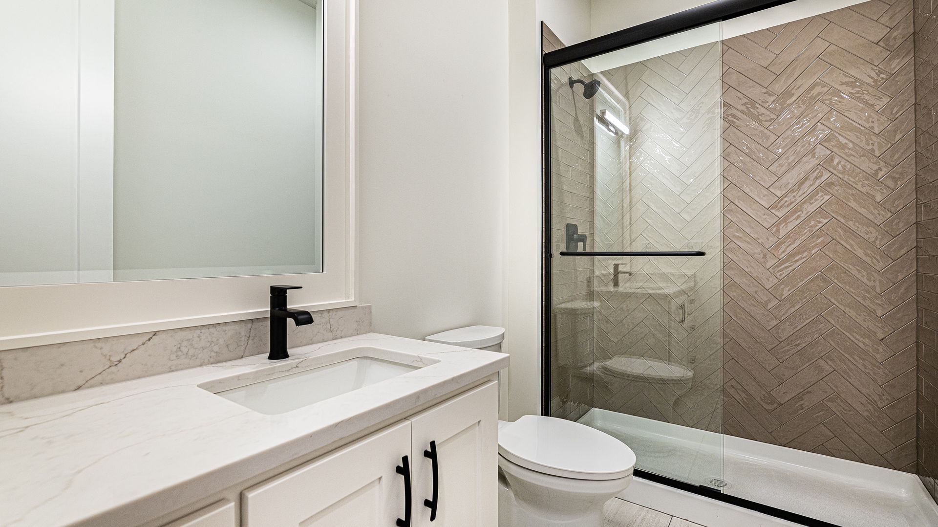 A bathroom with a toilet , sink , and shower.
