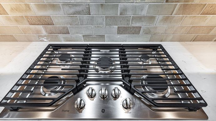 A stainless steel stove top oven is sitting on top of a counter.