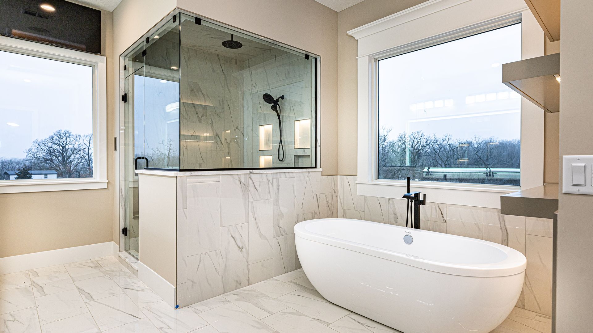 A bathroom with a tub , shower , and window.