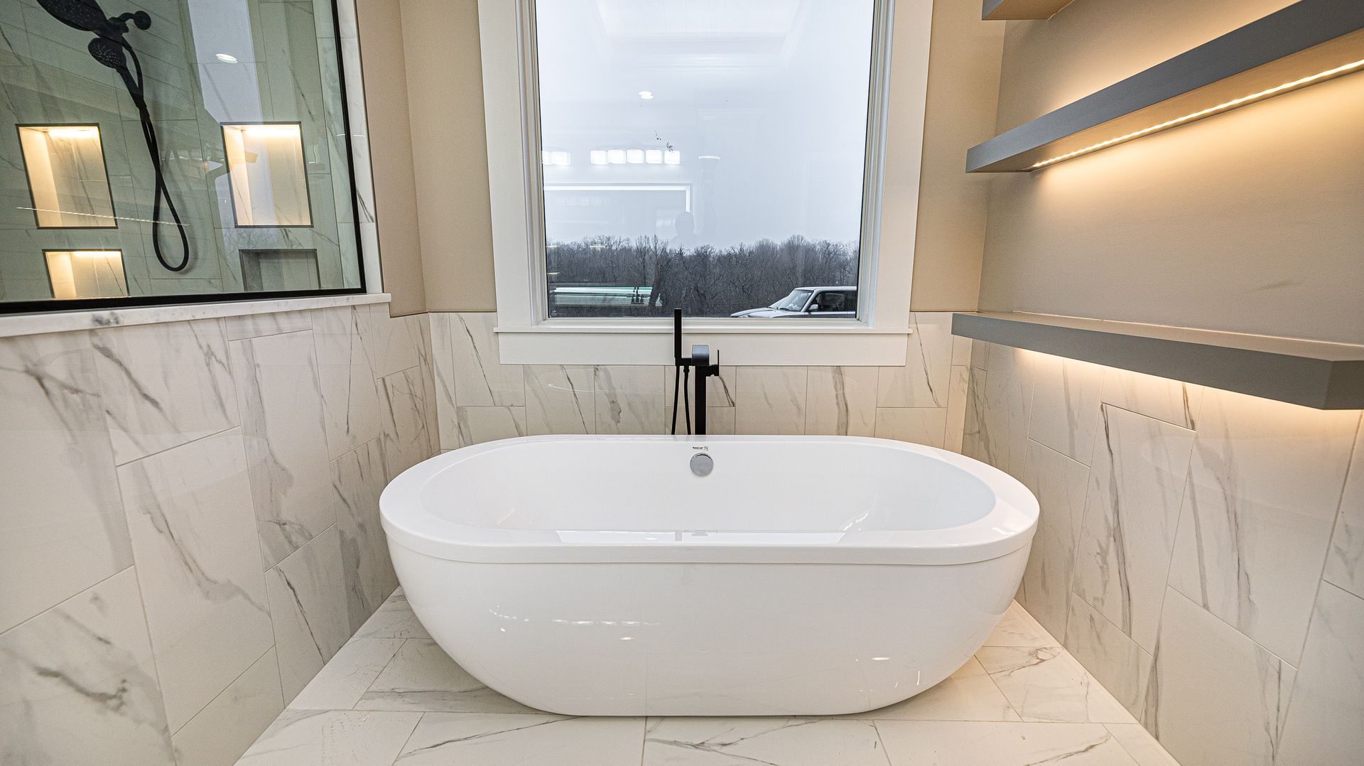 A bathroom with a bathtub and a window.