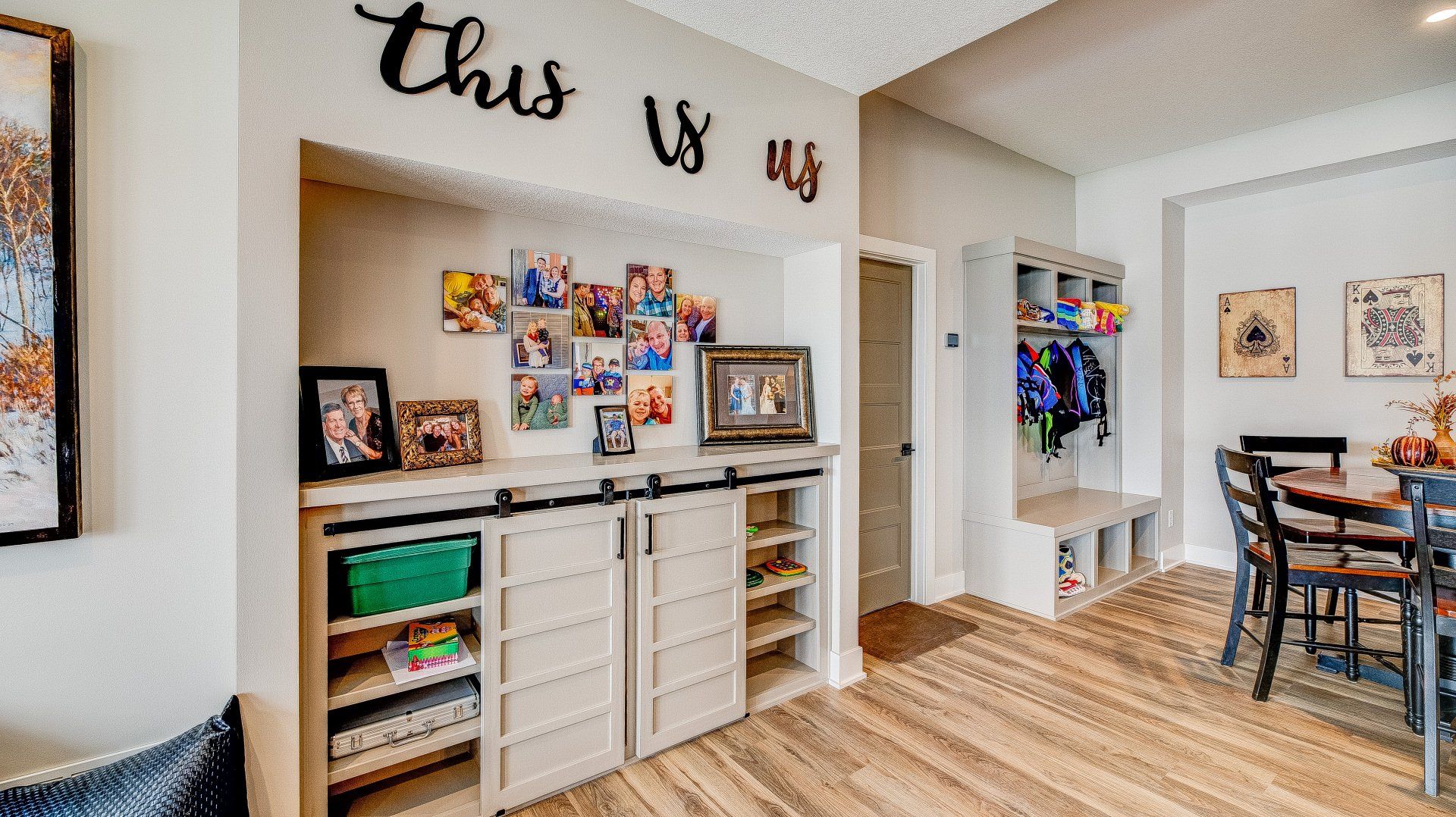 A living room with a dining table and chairs and a sliding barn door.