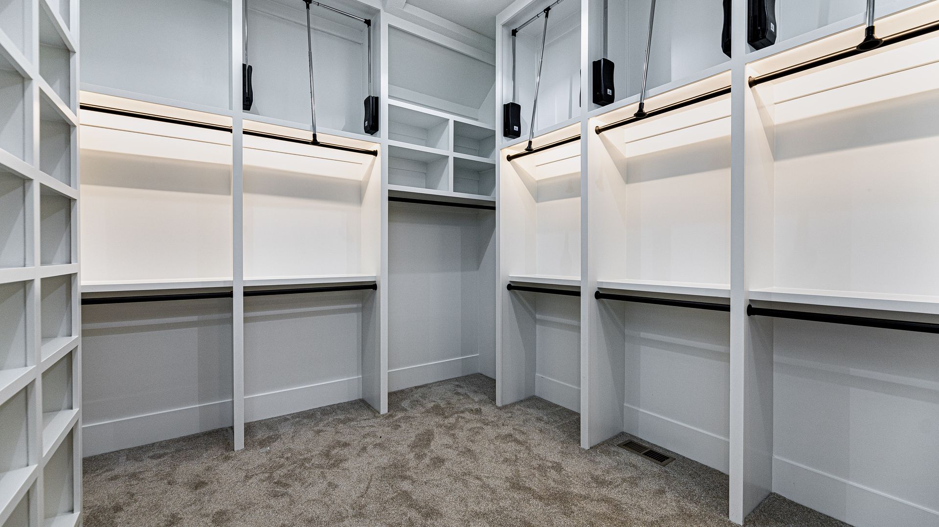A walk in closet with lots of shelves and hanging racks.